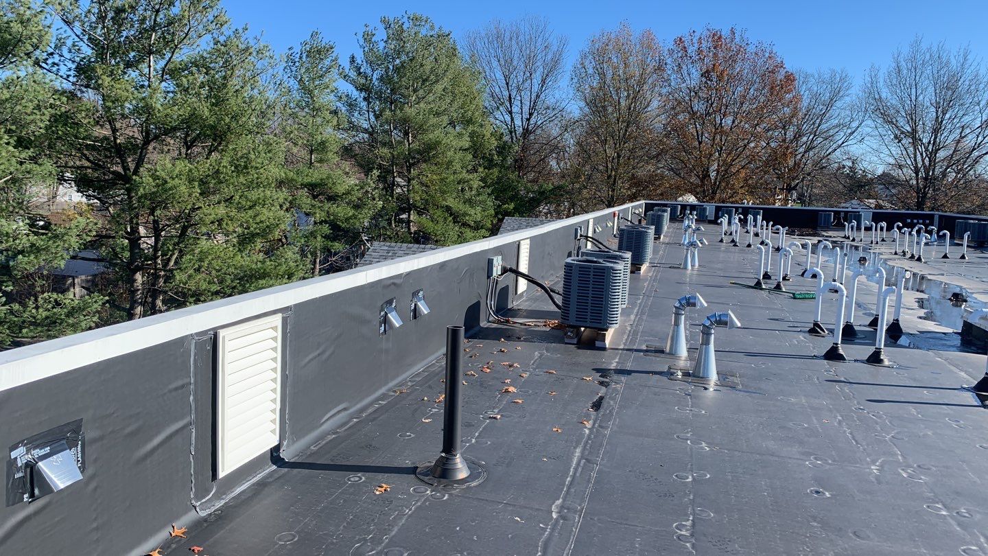 Commercial Roofing Installation using EPDM with white gutters by A Plus Exterior