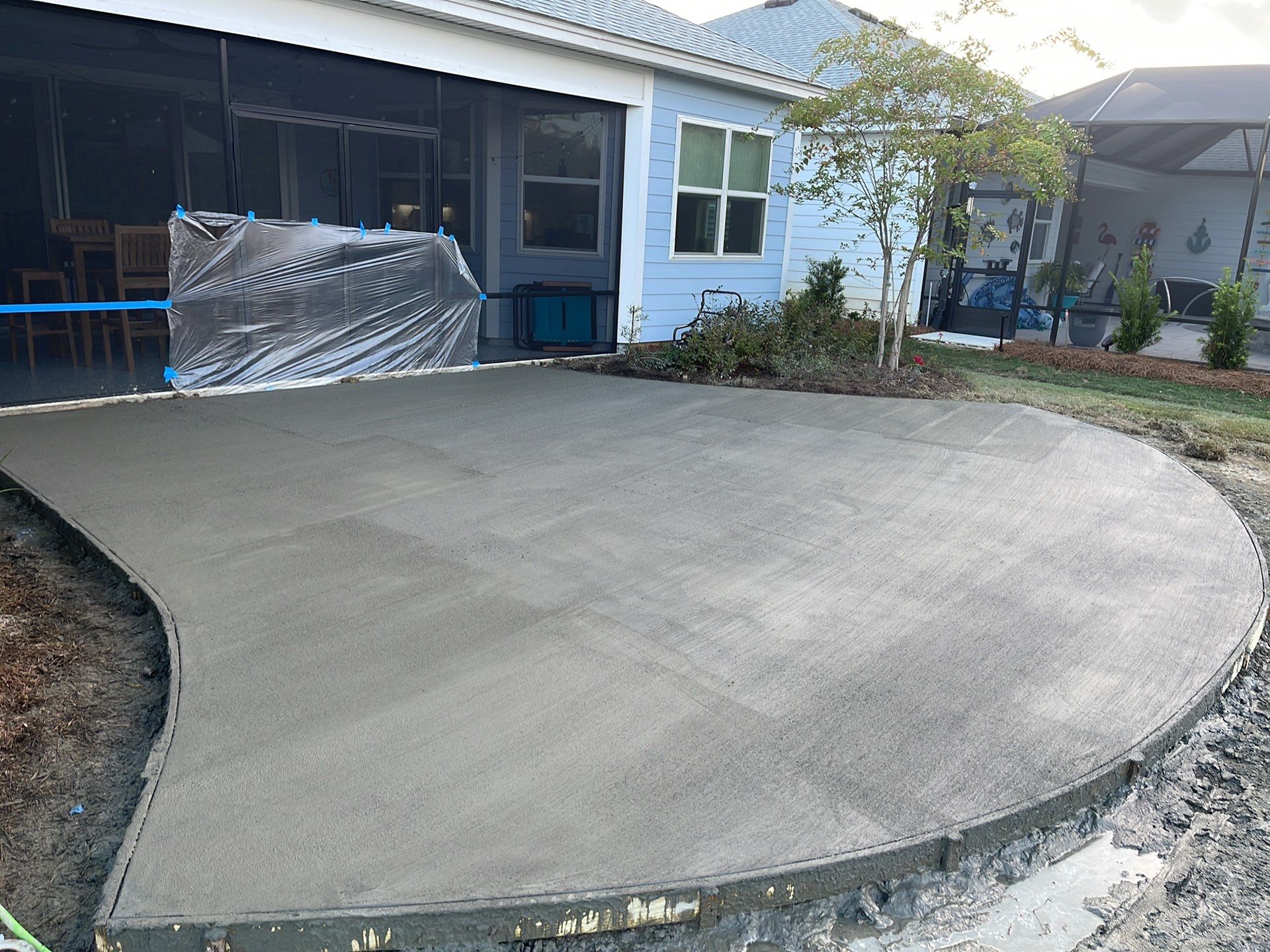 Custom Curved Concrete Patio and Paver Border in Hardeeville by Lowcountry Scapes, LLC