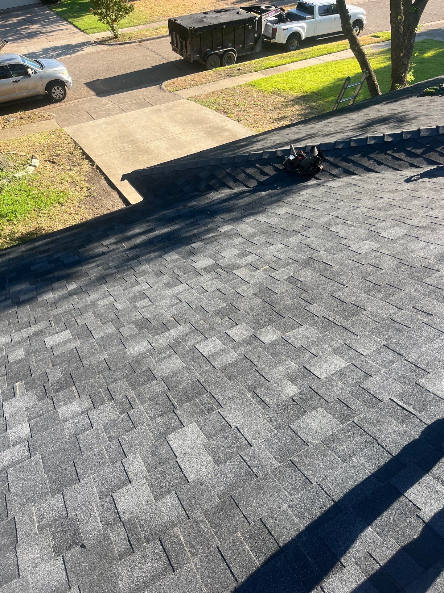 White brick/light gray shutters with IKO Granite Black  by Tejas Roofworks + Restoration