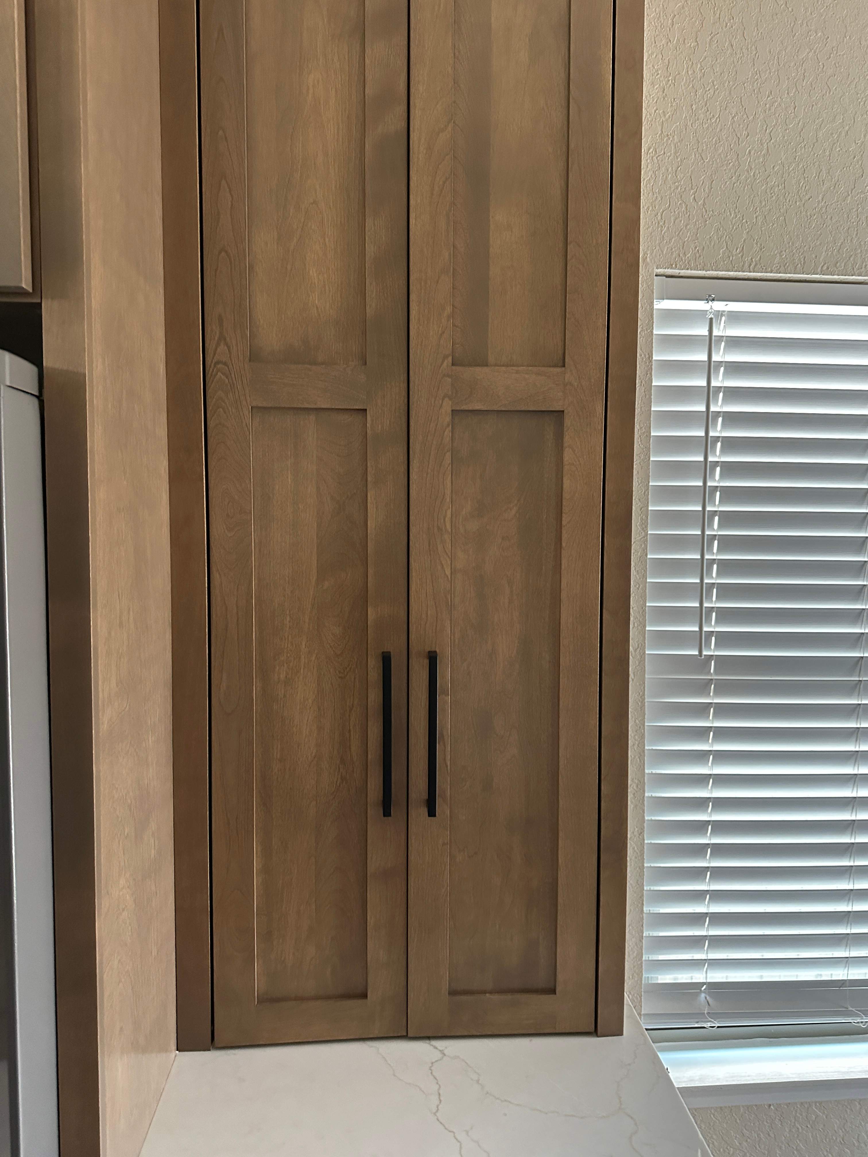 The old kitchen had a traditional builder-grade look with heavier wood cabinetry and busier finishes, while the new kitchen has a warm transitional design with cleaner lines, a brighter palette, and a more open, modern layout by Mena stone surfaces