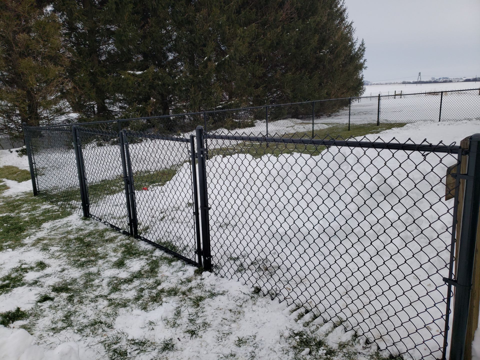 Black Vinyl-Coated Chain Link Fence Installation in Oelwein by Perfect Picket Fence and Stain