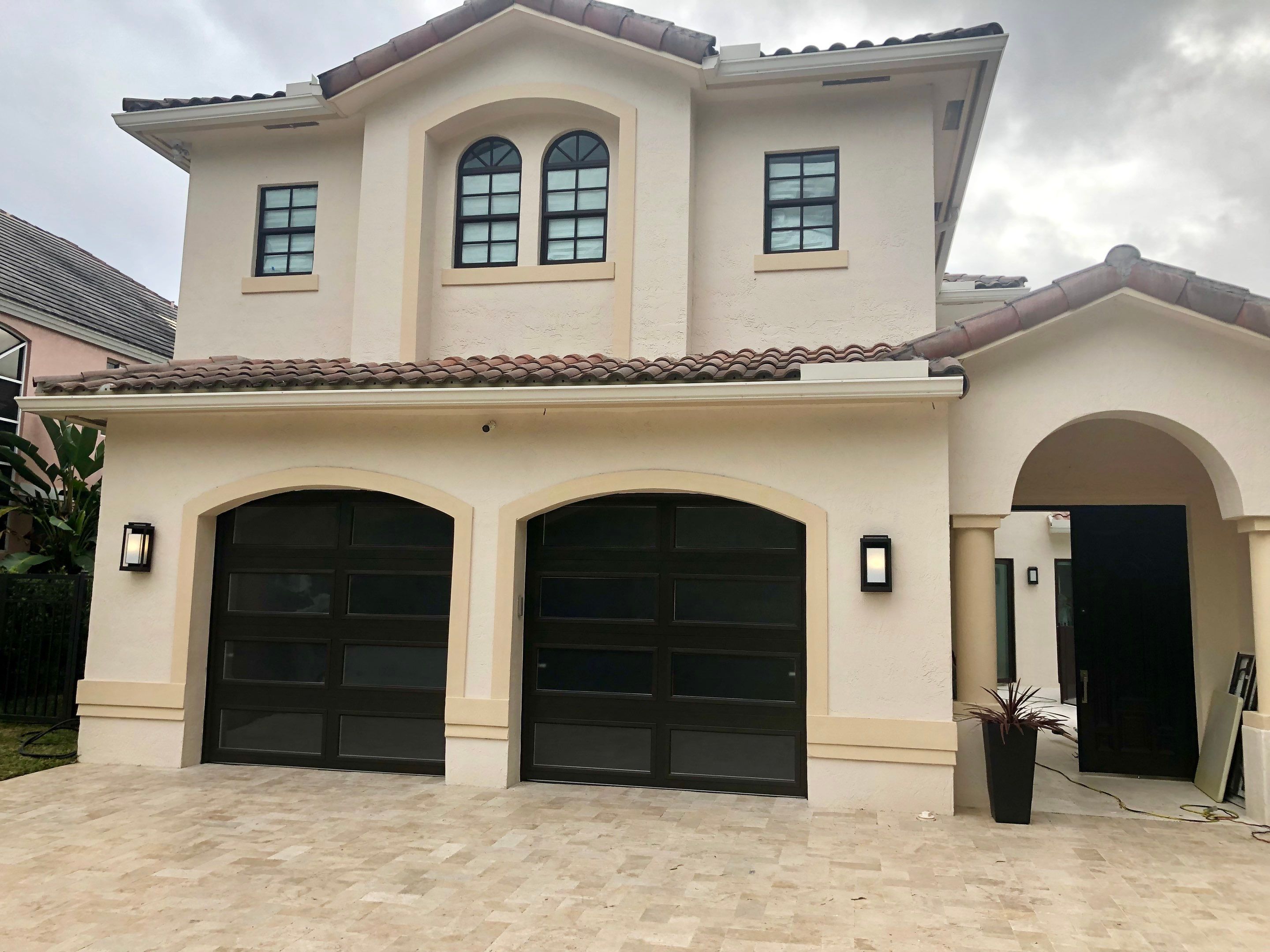 Modern Bronze Garage Door Installation With Frosted Glass in Boca Raton by The Door Doctor of South Florida, Inc.