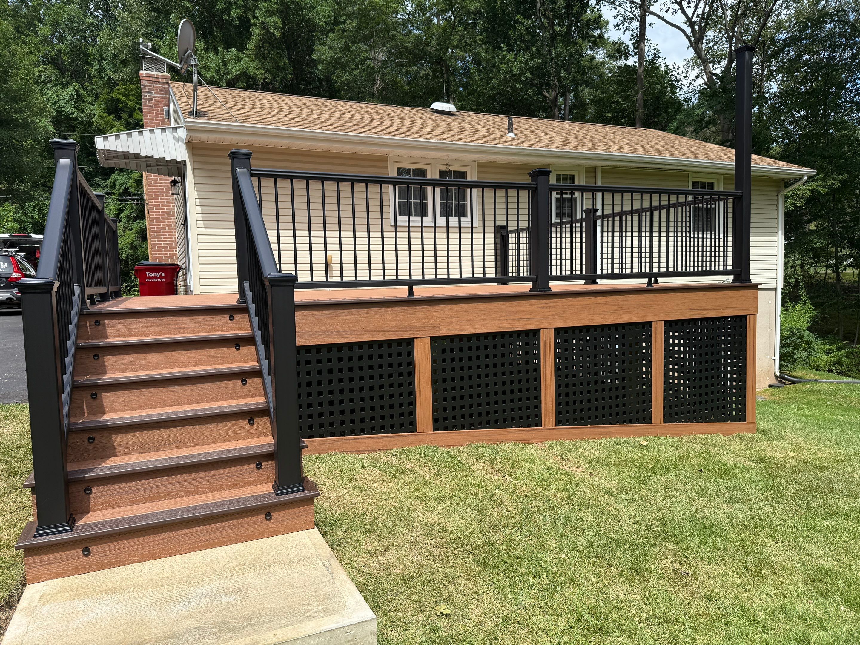 Replacement Deck, Trex Tropical Tiki torch , Matching Fascia. Black Transcend railing and Lattice. by DiGiorgi Roofing and Siding Inc