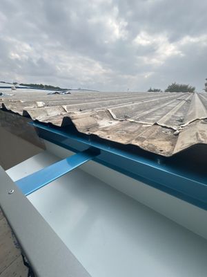 Completed metal roof edge with blue gutter system