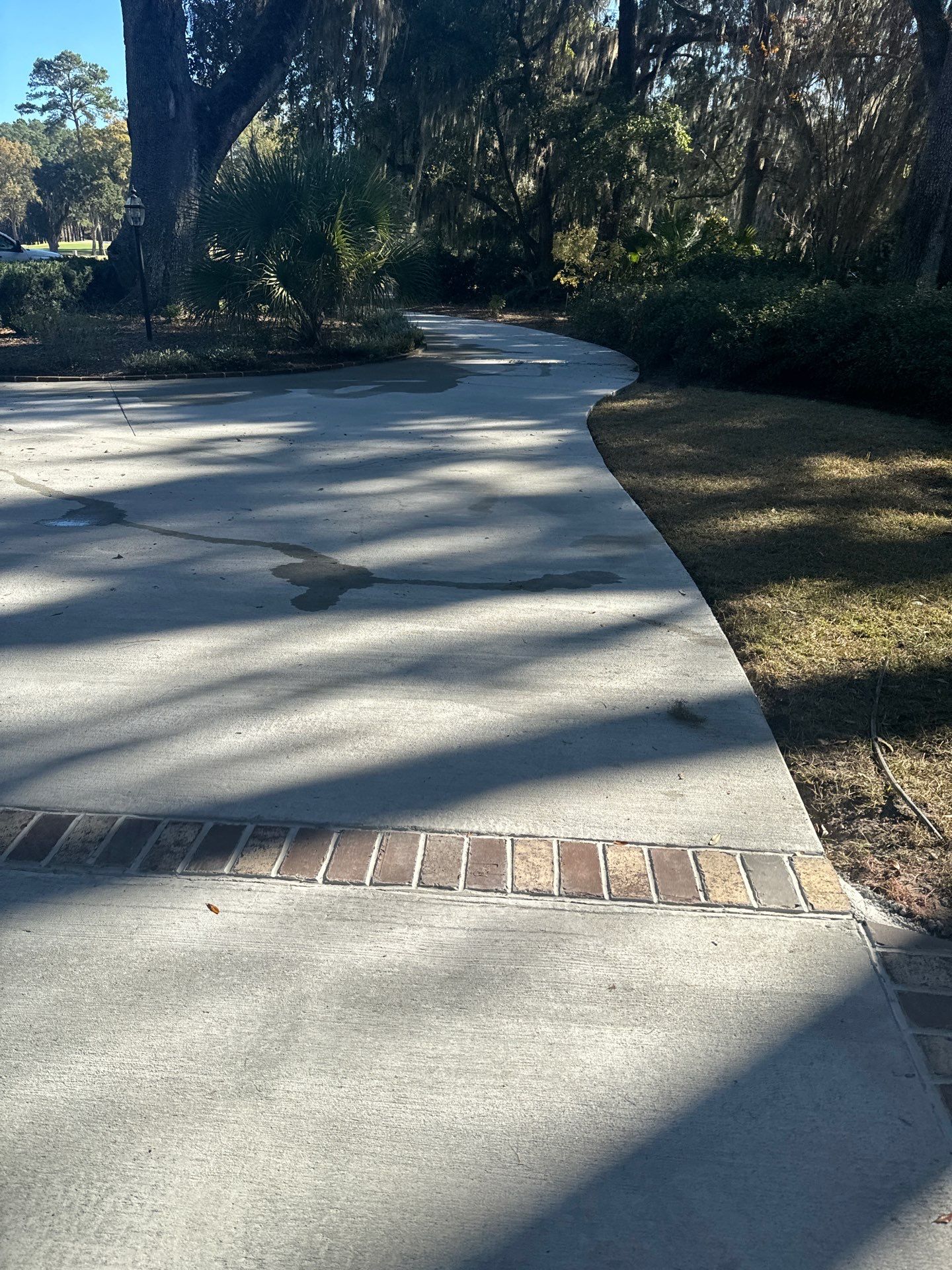 Custom Concrete Driveway Installation with Decorative Brick Borders in Okatie by Lowcountry Scapes, LLC