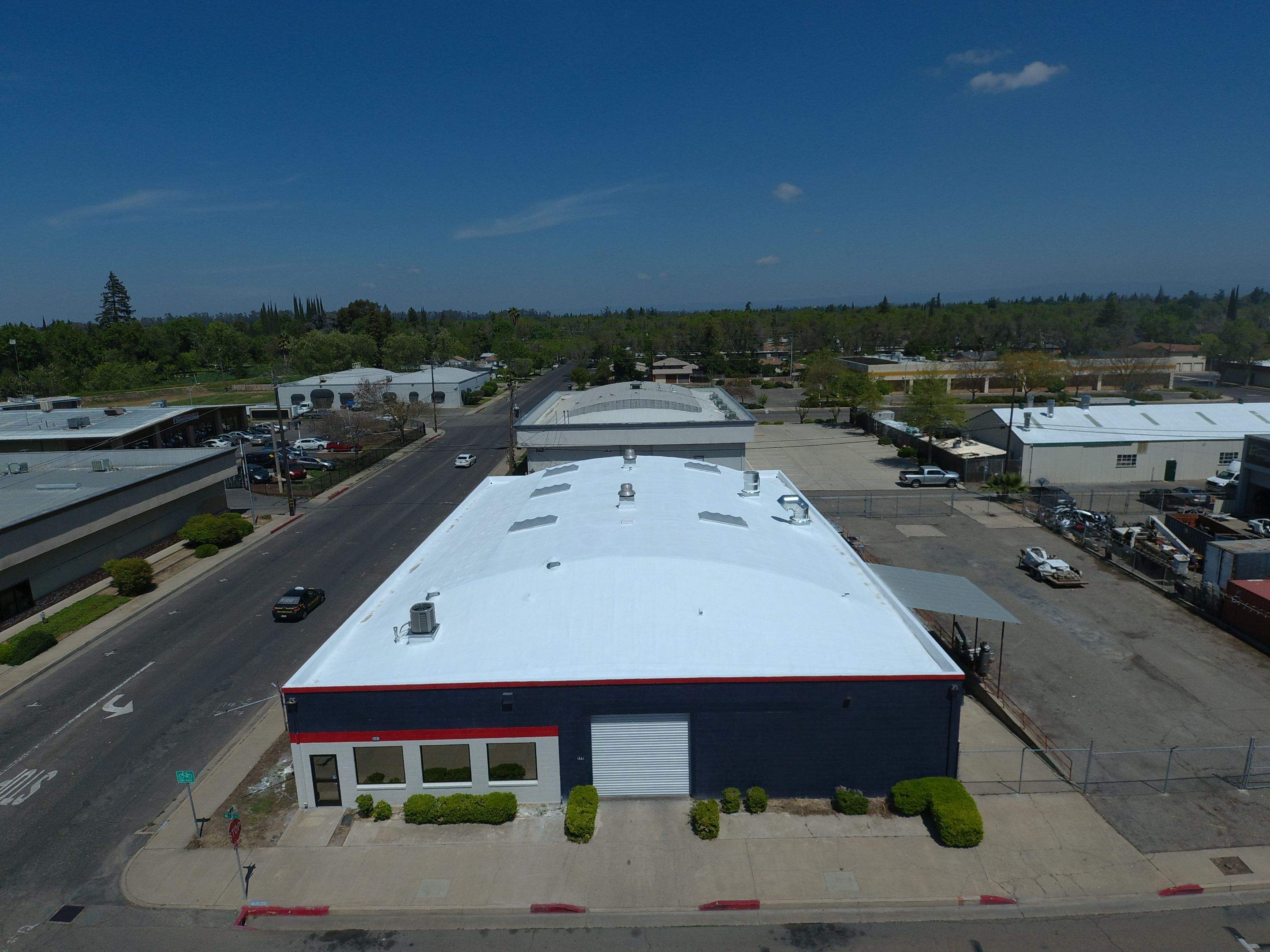 Spray foam and coatings using Conklin Benchmark/PUMA XL coatings on Auto Body Shop by Straight Edge Roofing Inc