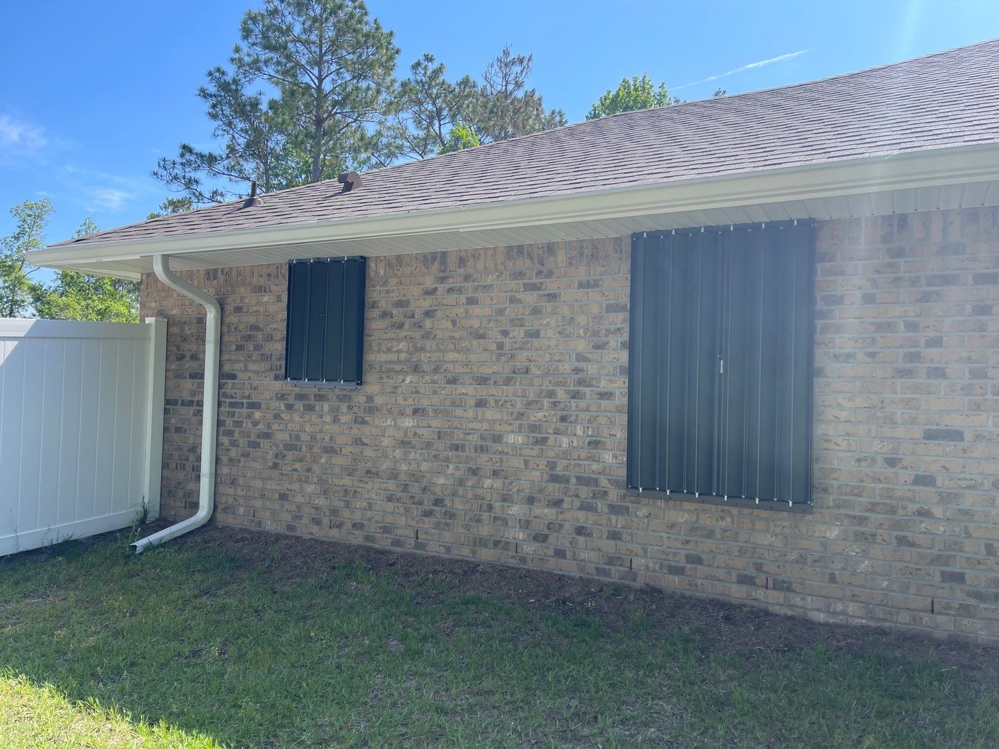 Bronze Accordions on brick home by Smart Guard Shutters