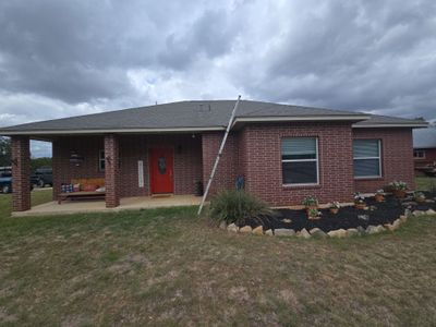 Architectural asphalt shingle roof with ladder leaning against house
