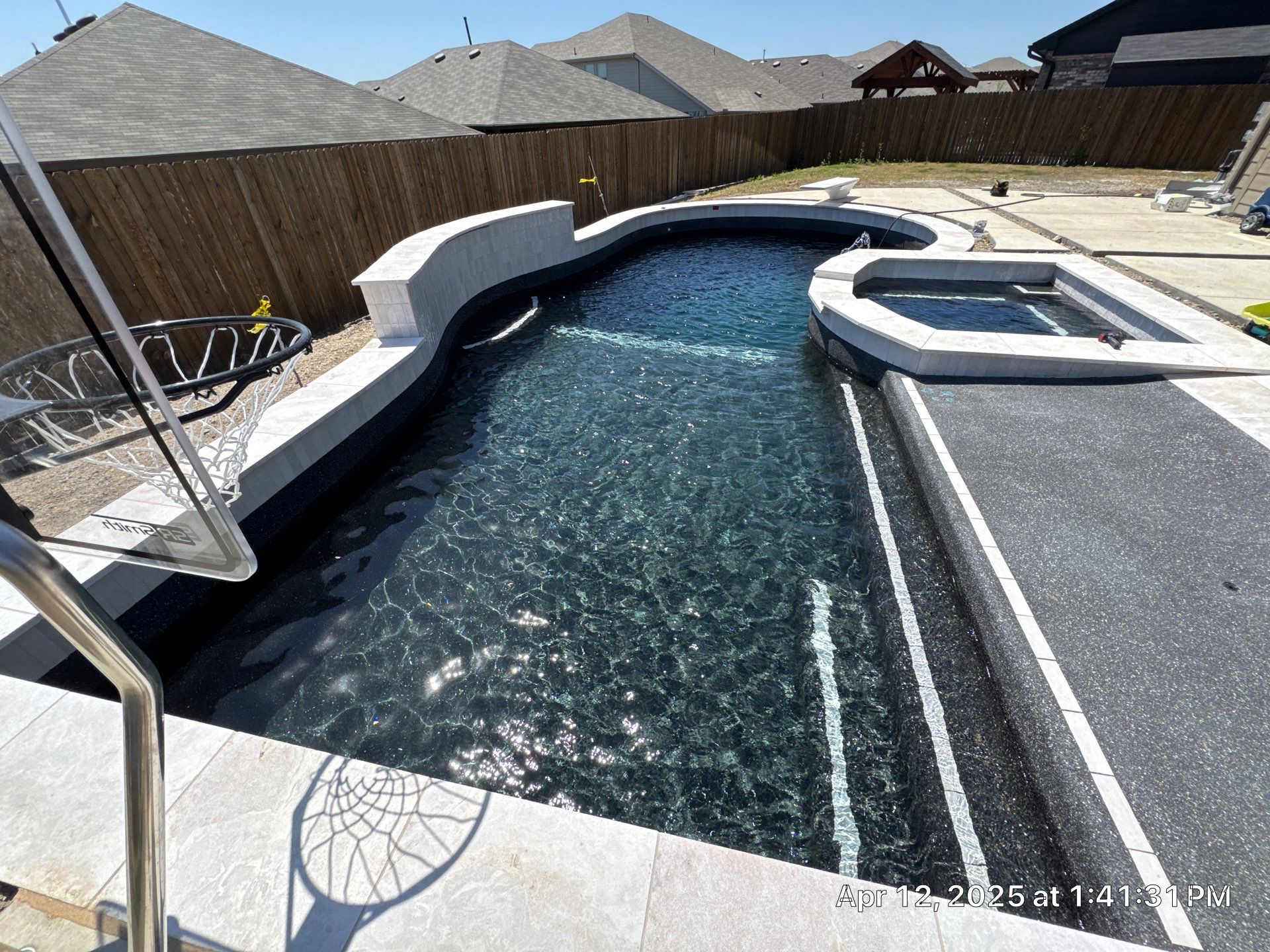 Geometric Pool with Spillover Spa and Dark Interior by Pinnacle Pools and Spas - DFW