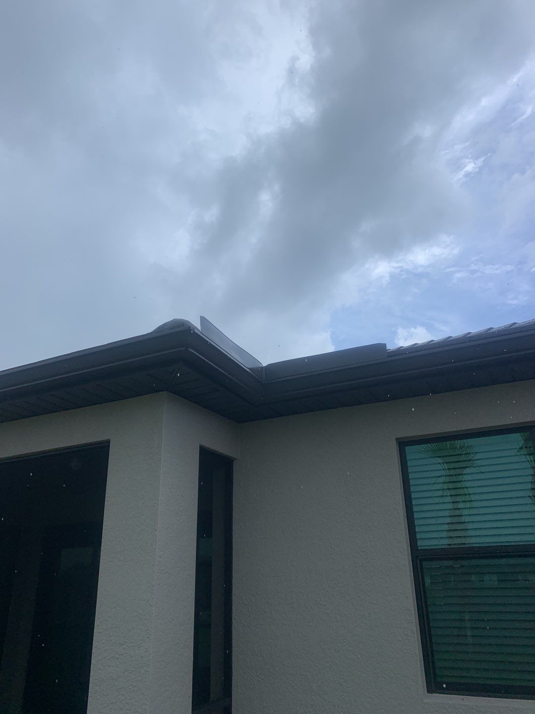 Seamless brown gutter and downspouts installation in Estero, FL  by Gutter Professors