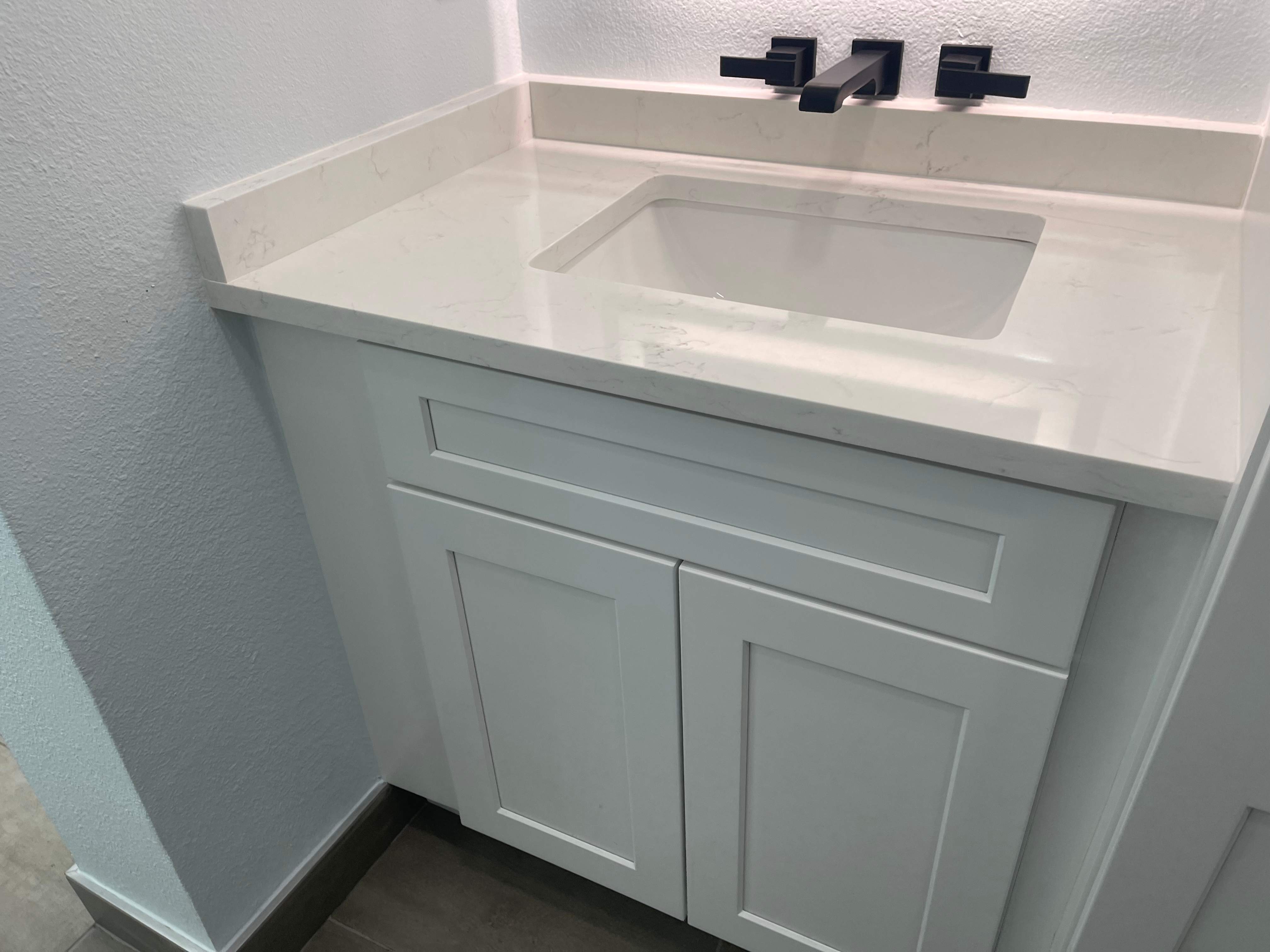 Complete Bathroom Remodel Featuring Marble Tile and Teal Herringbone Niche by Mena stone surfaces