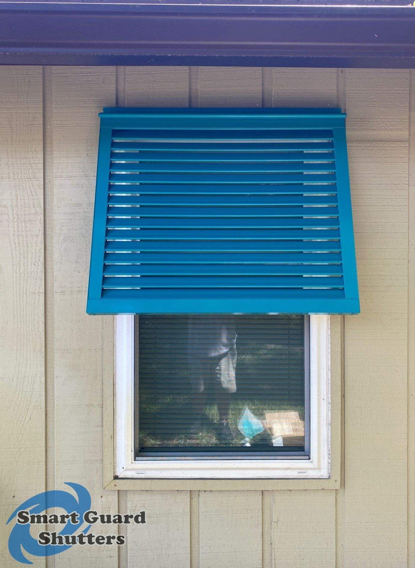 Decorative Bahama Shutters in Turquoise Blue  by Smart Guard Shutters