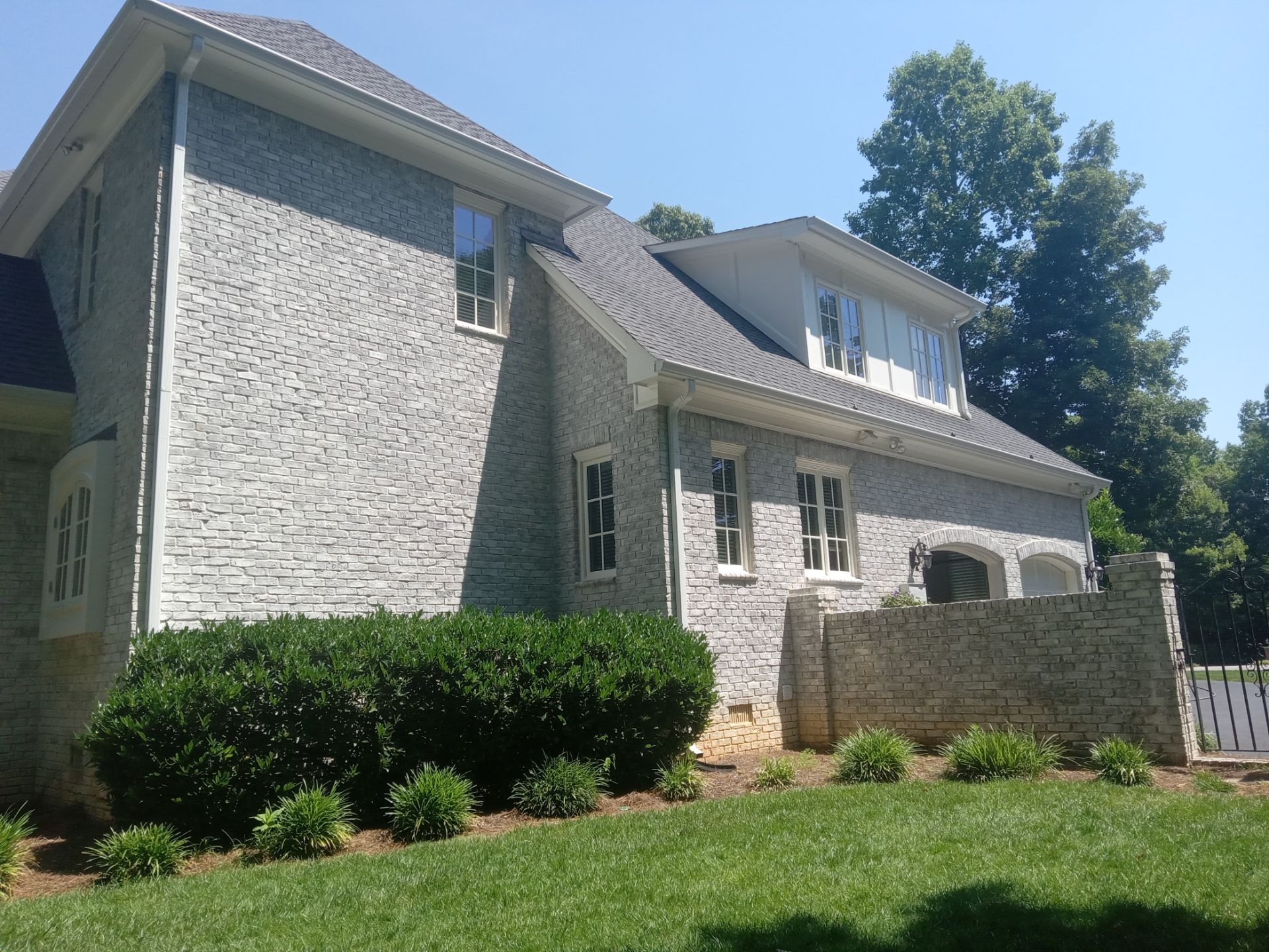 pressure washing exterior home surfaces including brick siding driveway and walkways for cleanliness and maintenance