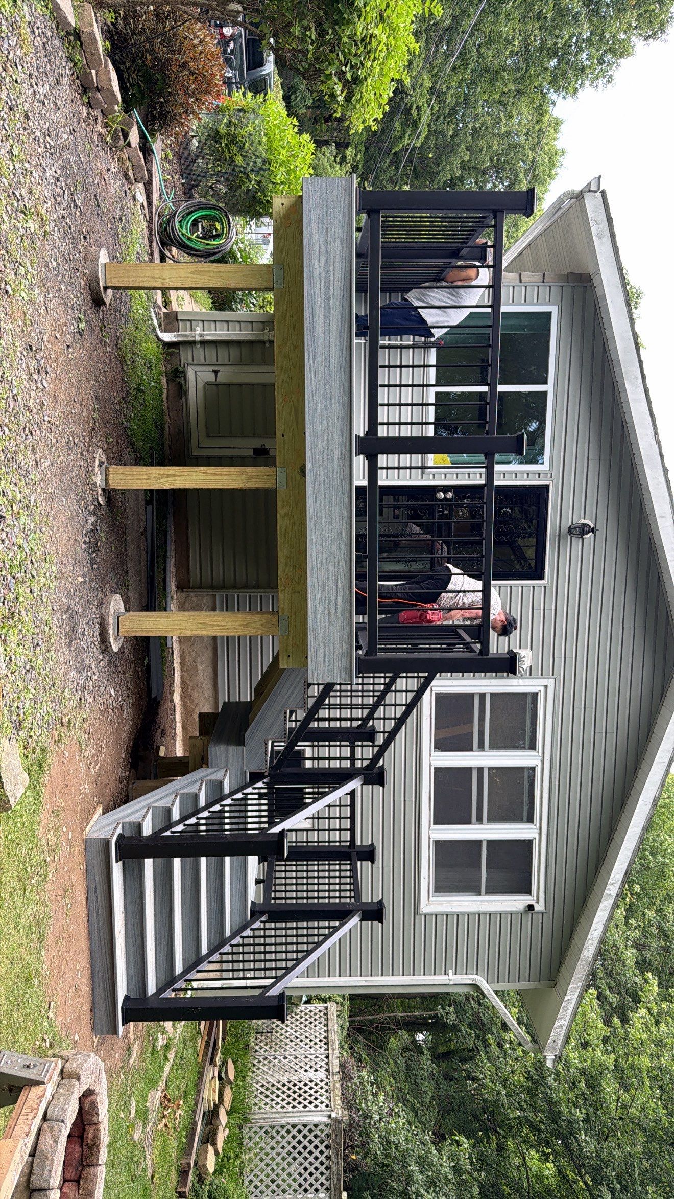 Raised Gray Composite Deck and Staircase Construction in Pocono Summit, PA by Herts Roofing & Construction