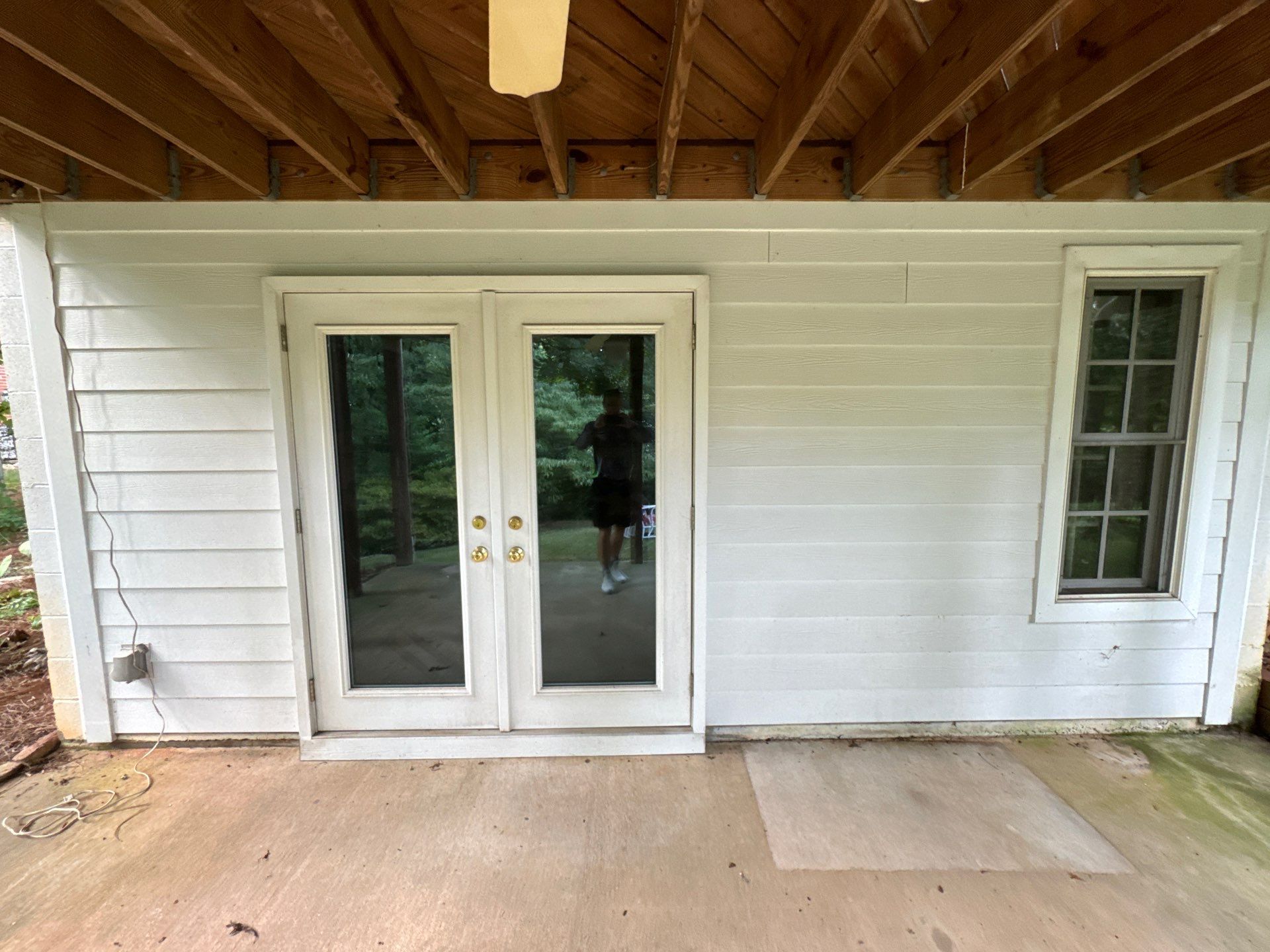 pressure washing company cleaning siding and concrete patio under deck in winston salem nc