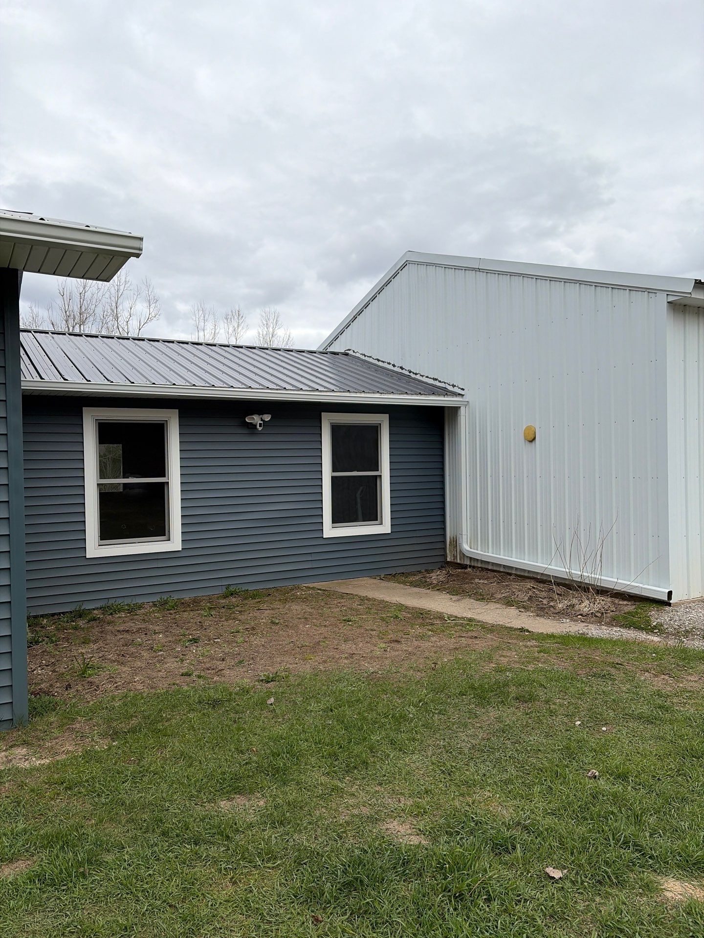 White Gutter and Downspout Installation for Boyne Falls Residential Property by Rainbow Seamless Systems