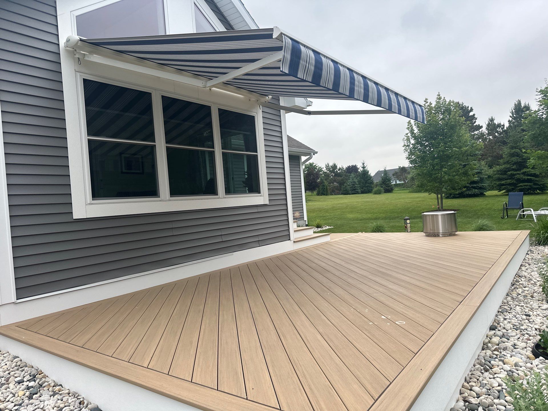 Sunesta Retractable Awning and Composite Deck Installation in Petoskey by Rainbow Seamless Systems