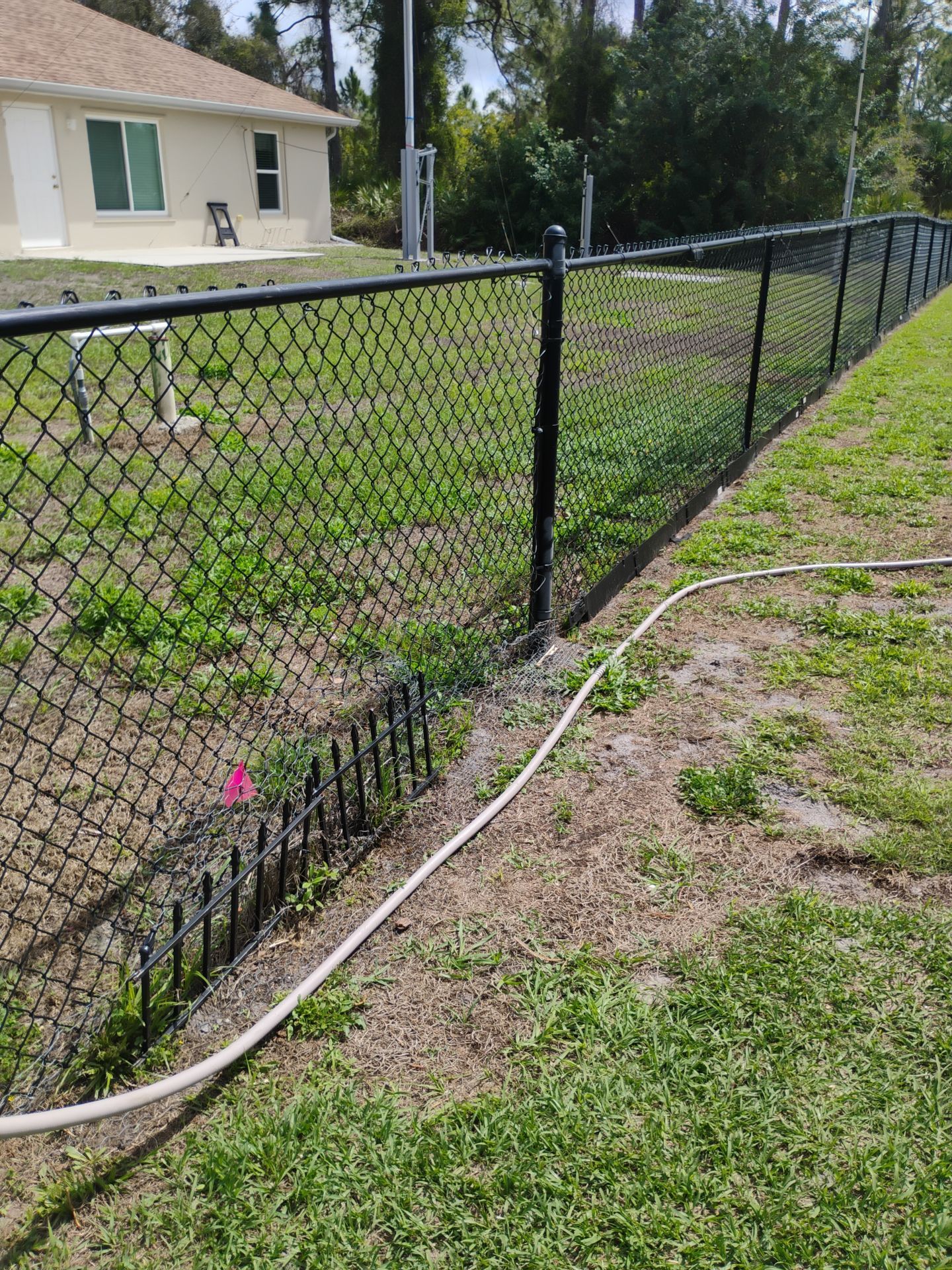 Black Vinyl-Coated Chain Link Fence and Rolling Gate Installation in North Port by True Fence LLC