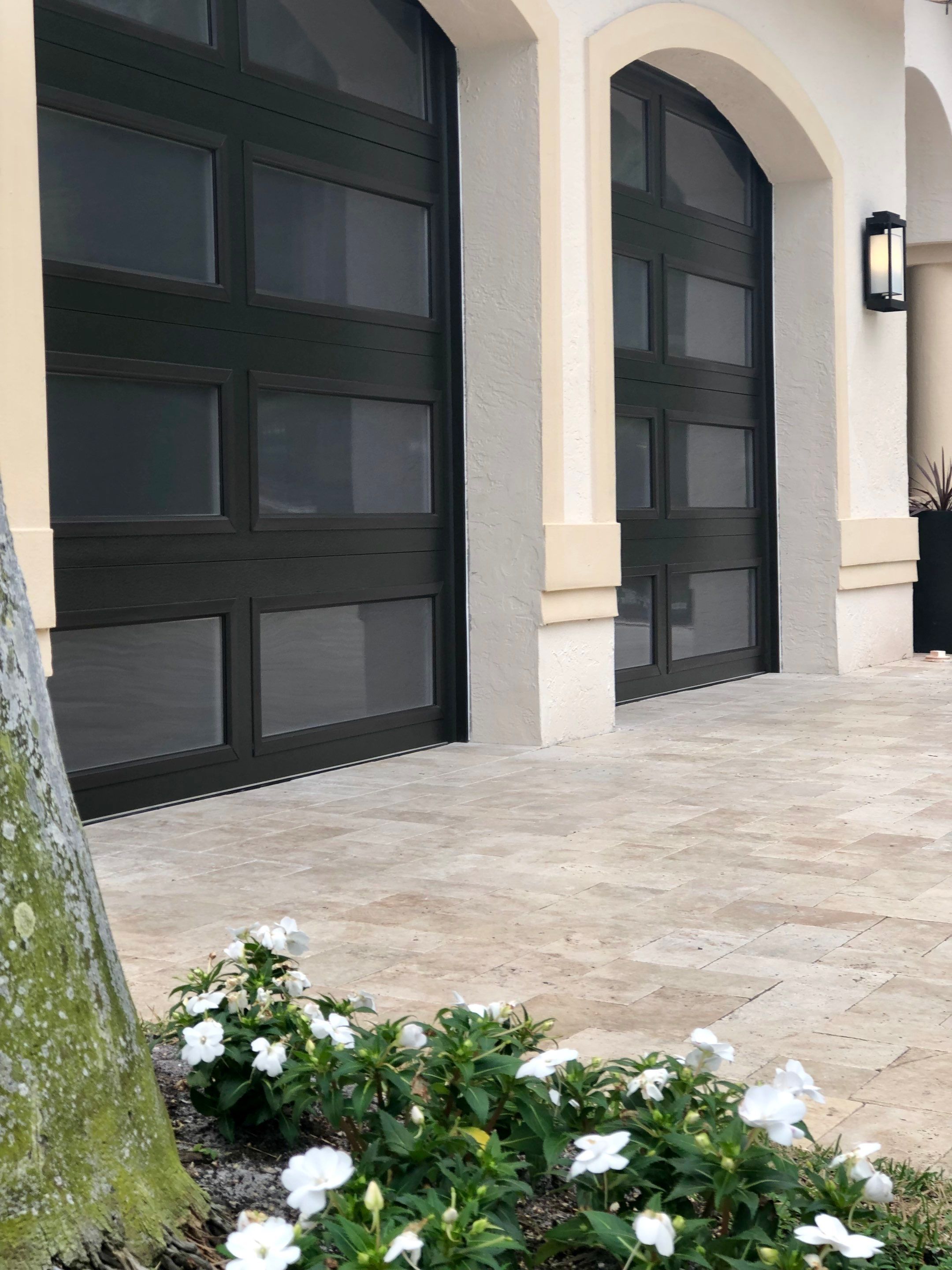 Modern Bronze Garage Door Installation With Frosted Glass in Boca Raton by The Door Doctor of South Florida, Inc.