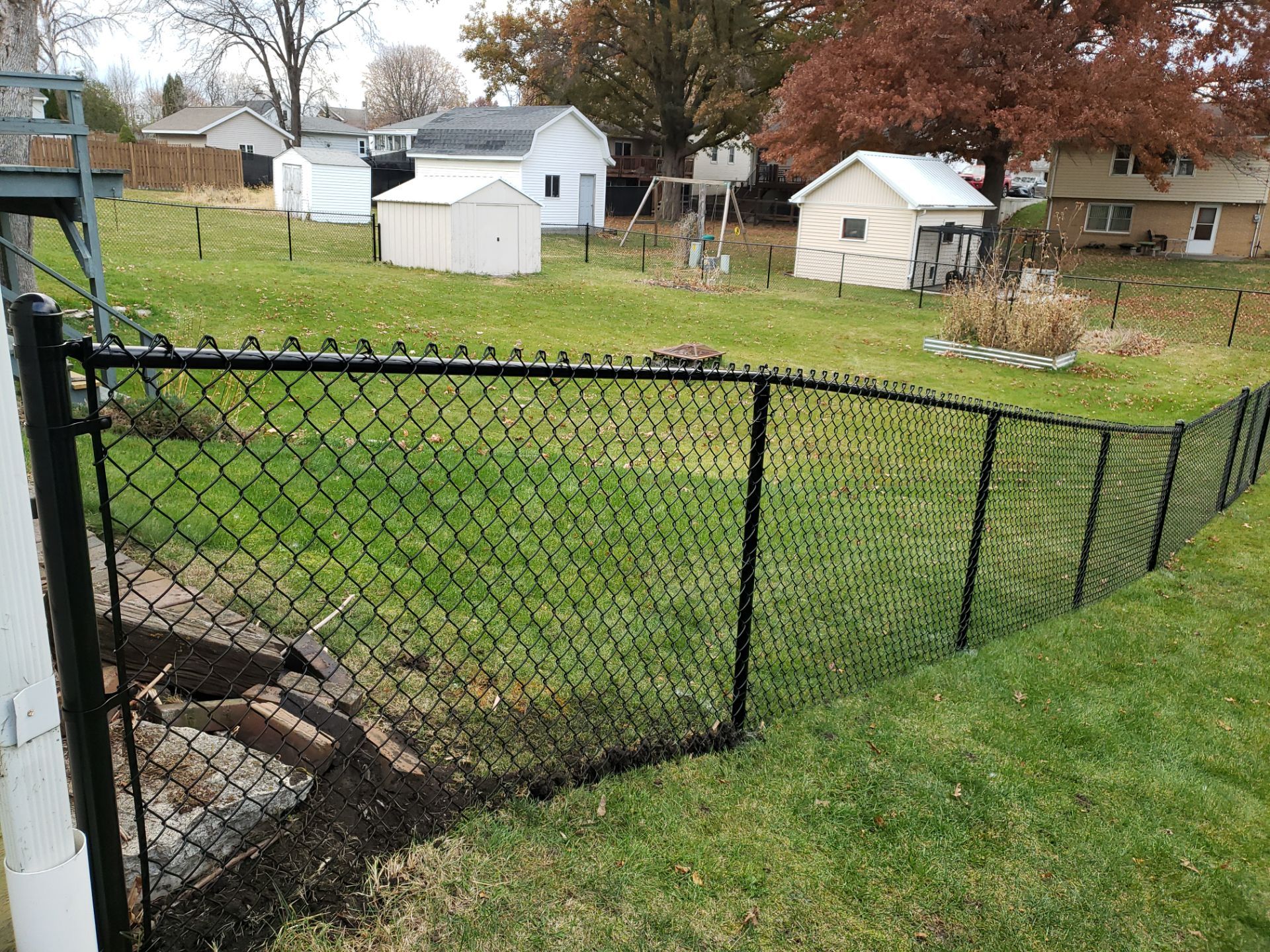 Residential Black Vinyl-Coated Chain Link Fence in Grundy Center by Perfect Picket Fence and Stain