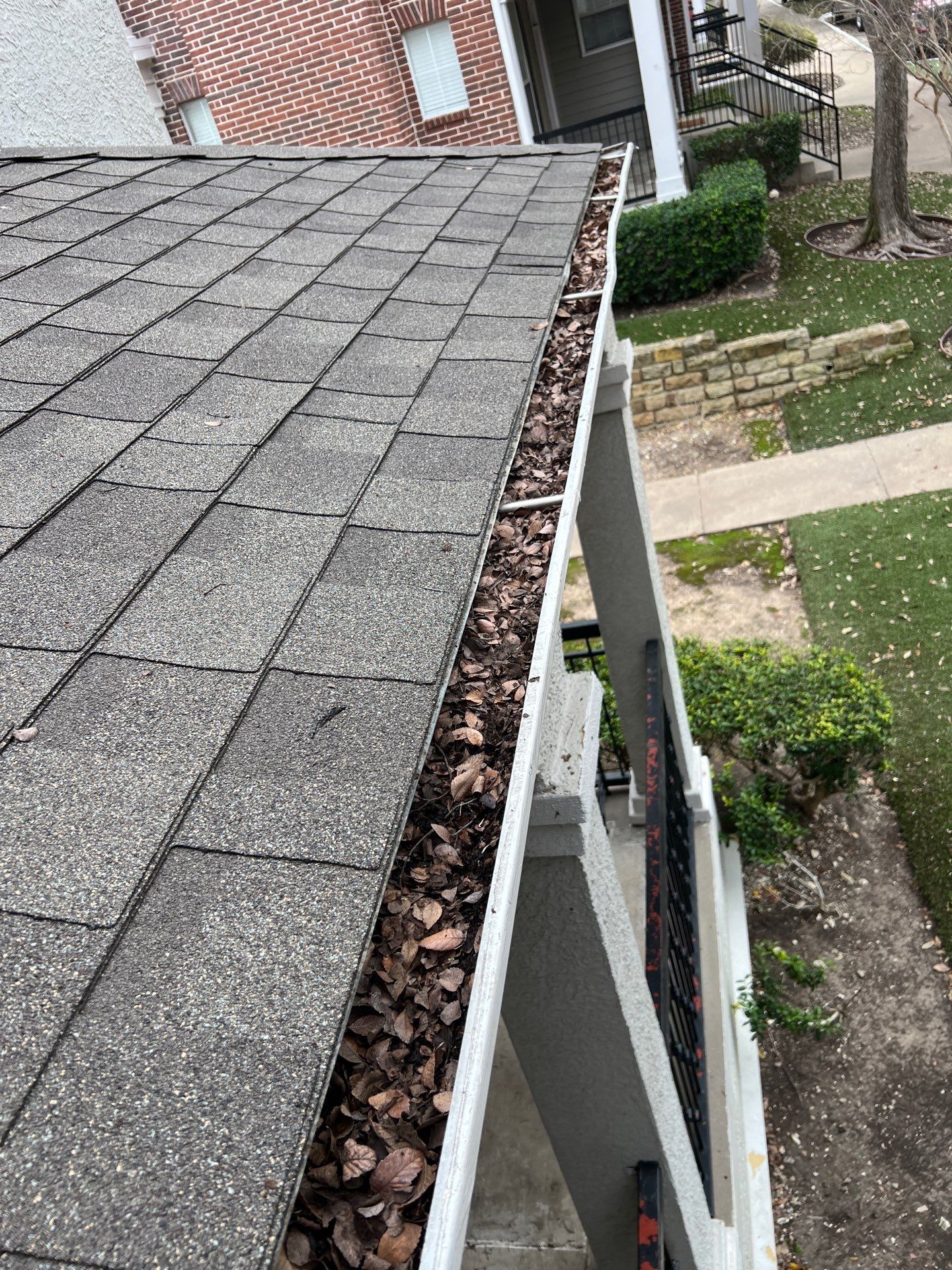 Commercial gutter cleaning Carrollton, TX before photo with filled gutters