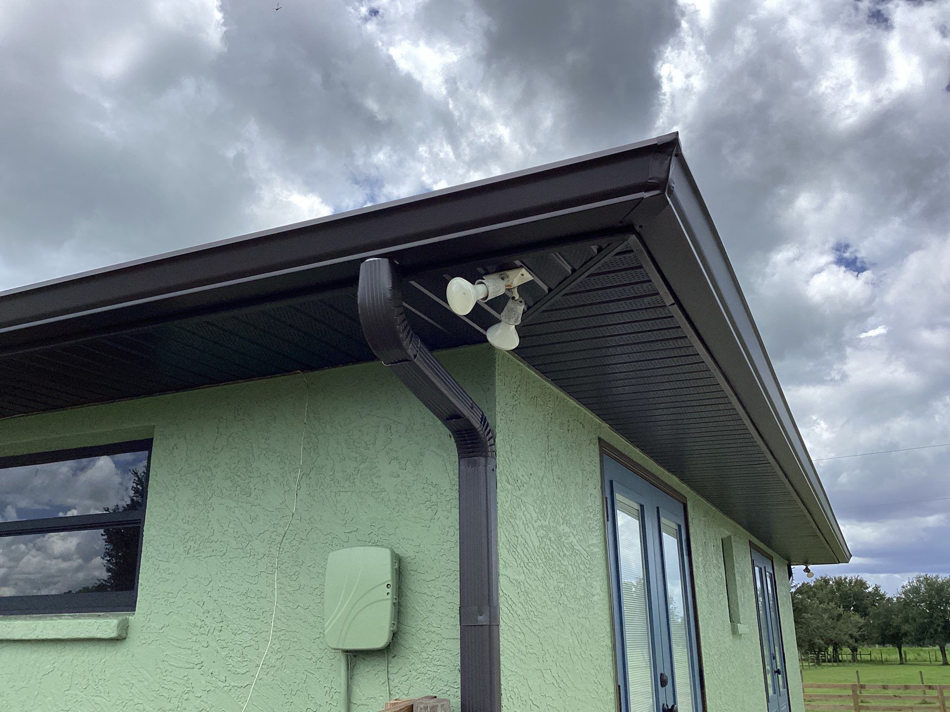 Musket brown downspouts with 6-inch K-Style gutter installation in Myakka City, FL by Gutter Professors