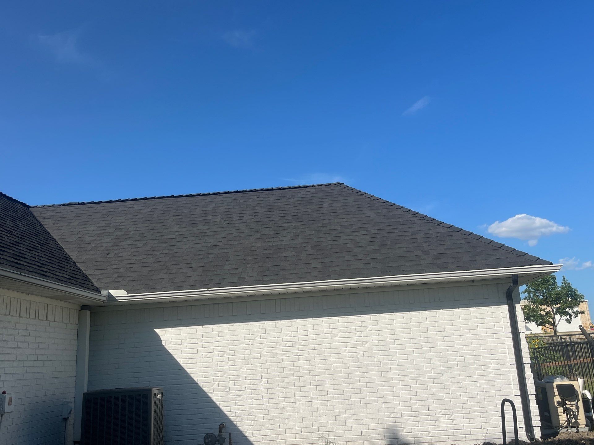 White brick with Malarkey Brilliant Black by Tejas Roofworks + Restoration