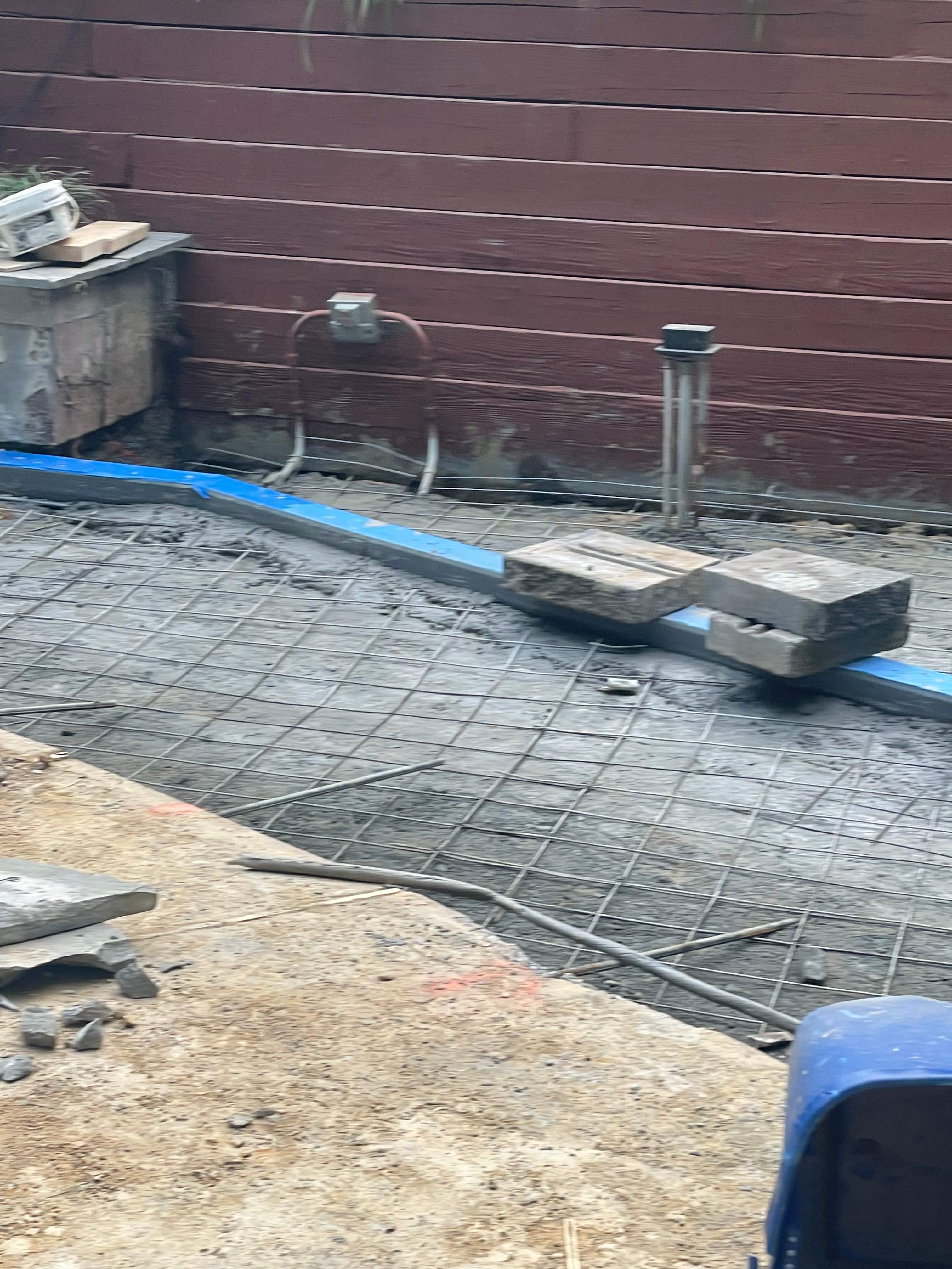 Pool Surround remodel with retaining walls, new waterfall and water slide by Fairfax Contractors, LLC