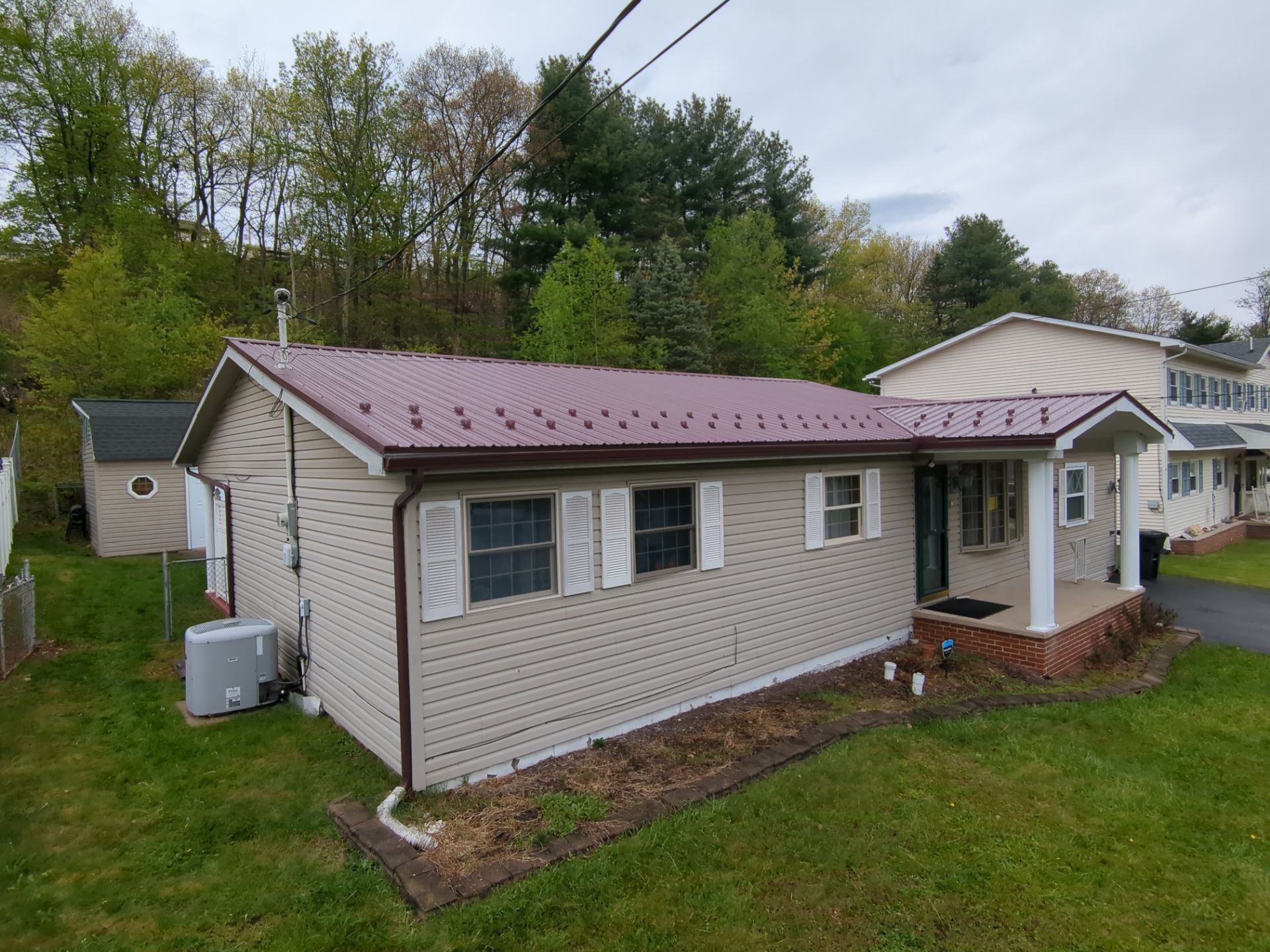 Maroon ABM Metal Roof Replacement and Gutter Installation in Shenandoah by Esh Builders