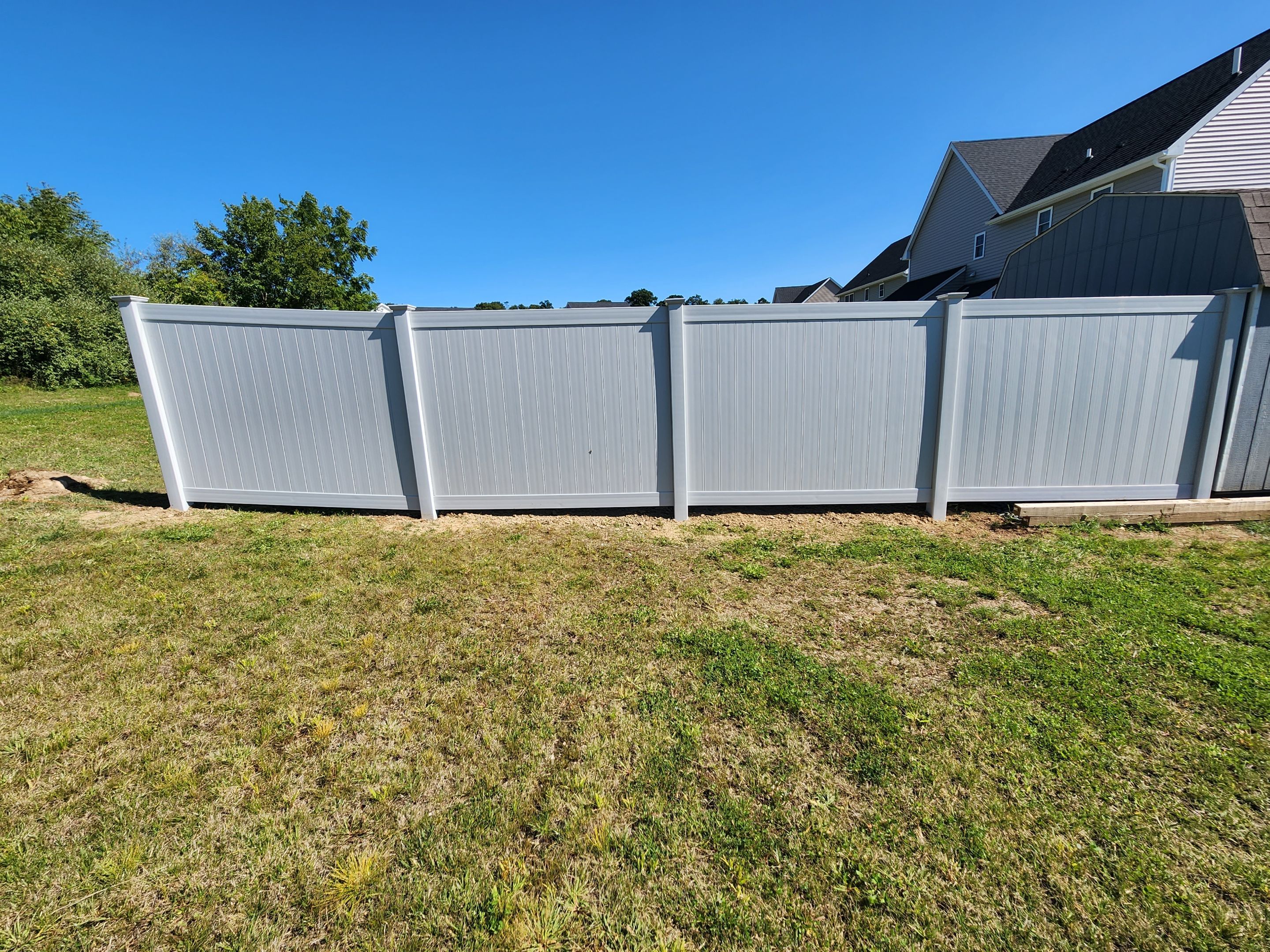New Vinyl privacy fence with matching gates in Classic Gray by DiGiorgi Roofing and Siding Inc