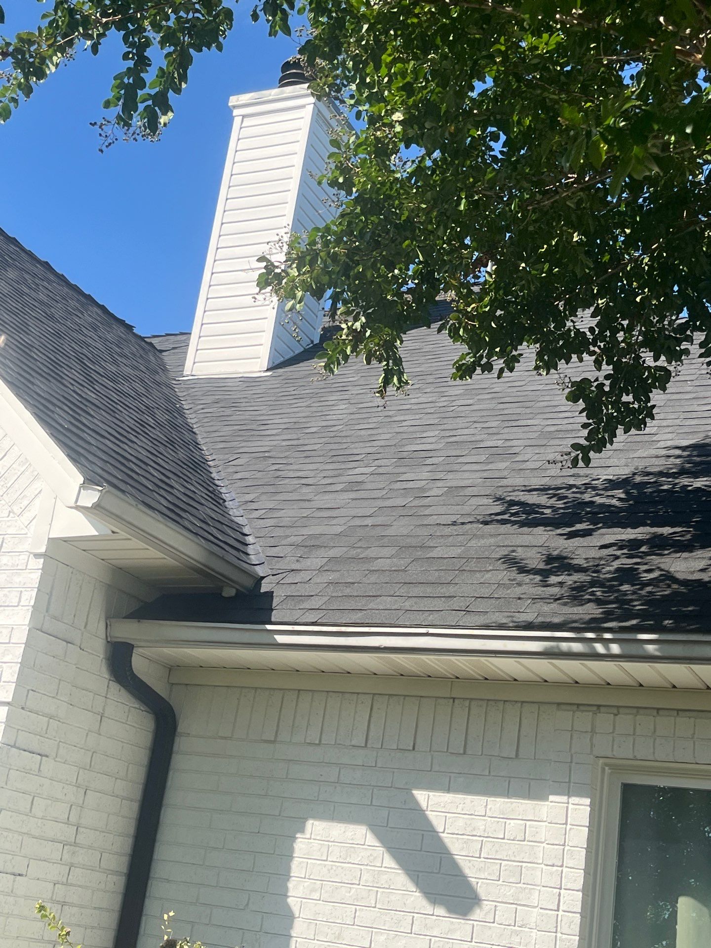 White brick with Malarkey Brilliant Black by Tejas Roofworks + Restoration