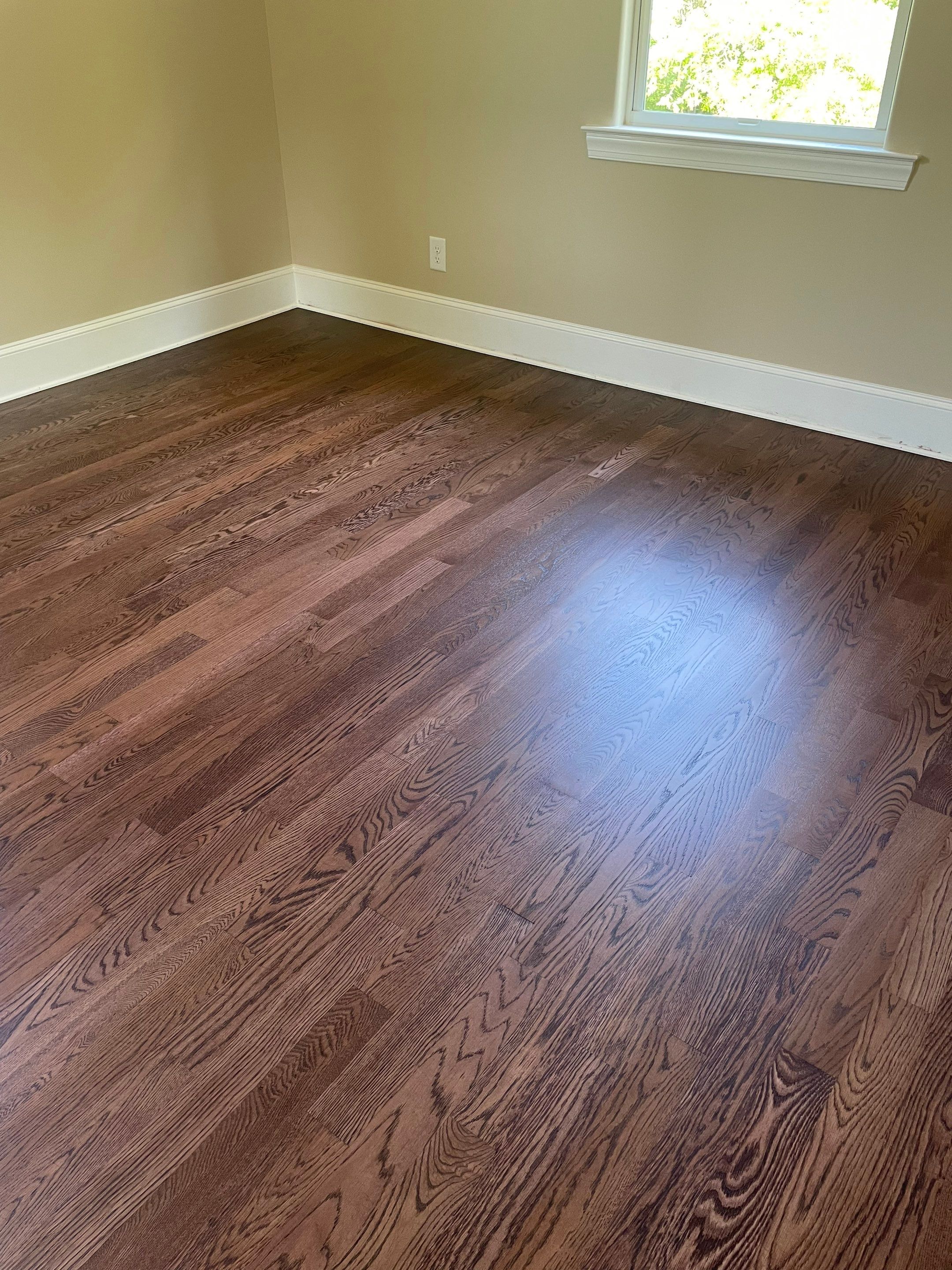 New white oak floors, stained a red tone. by Accent Custom Floors