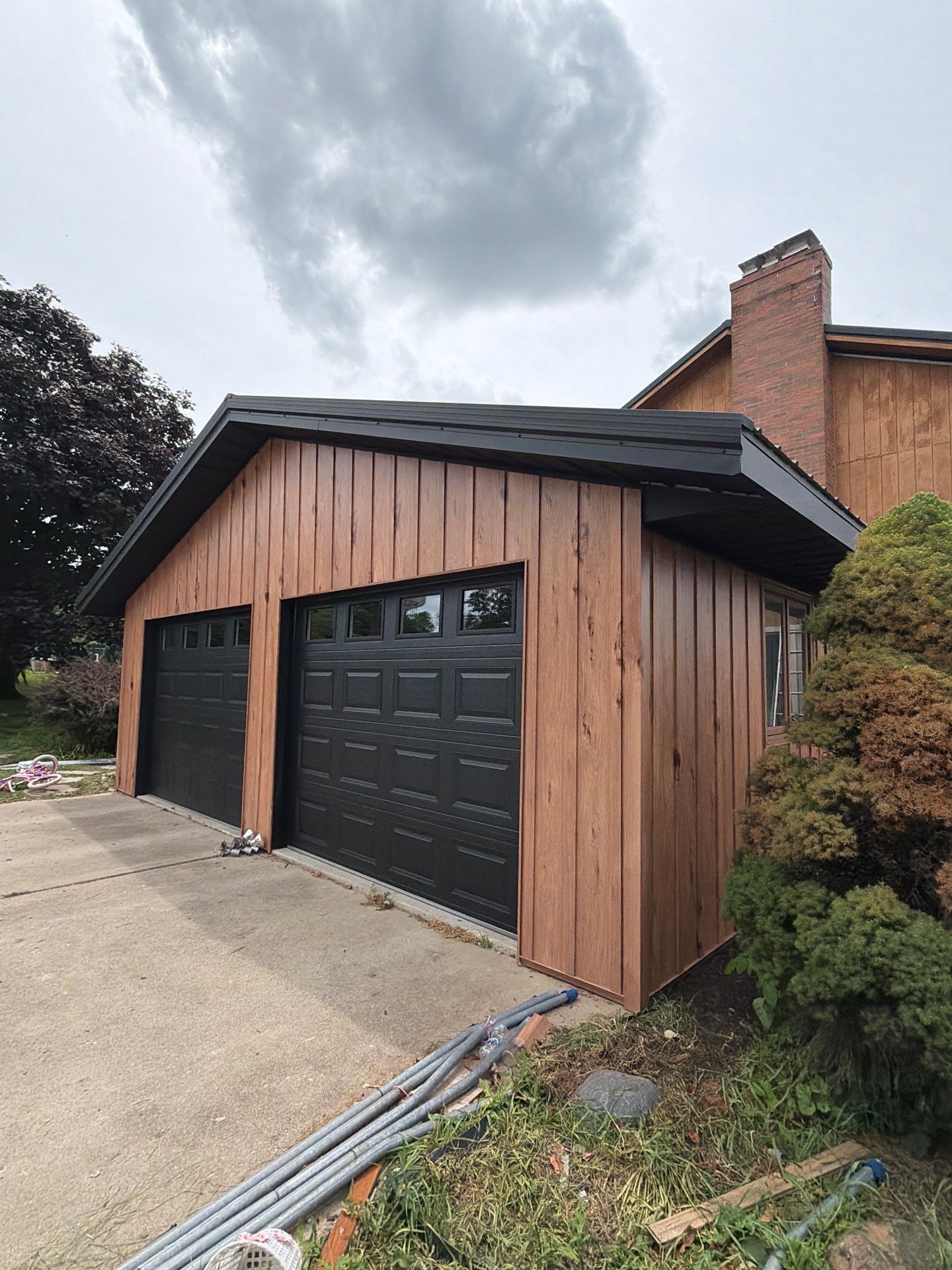 Complete Exterior Transformation with Textured Black Metal Roofing and Hickory Board-and-Batten Siding in Hebron by BZ Exteriors