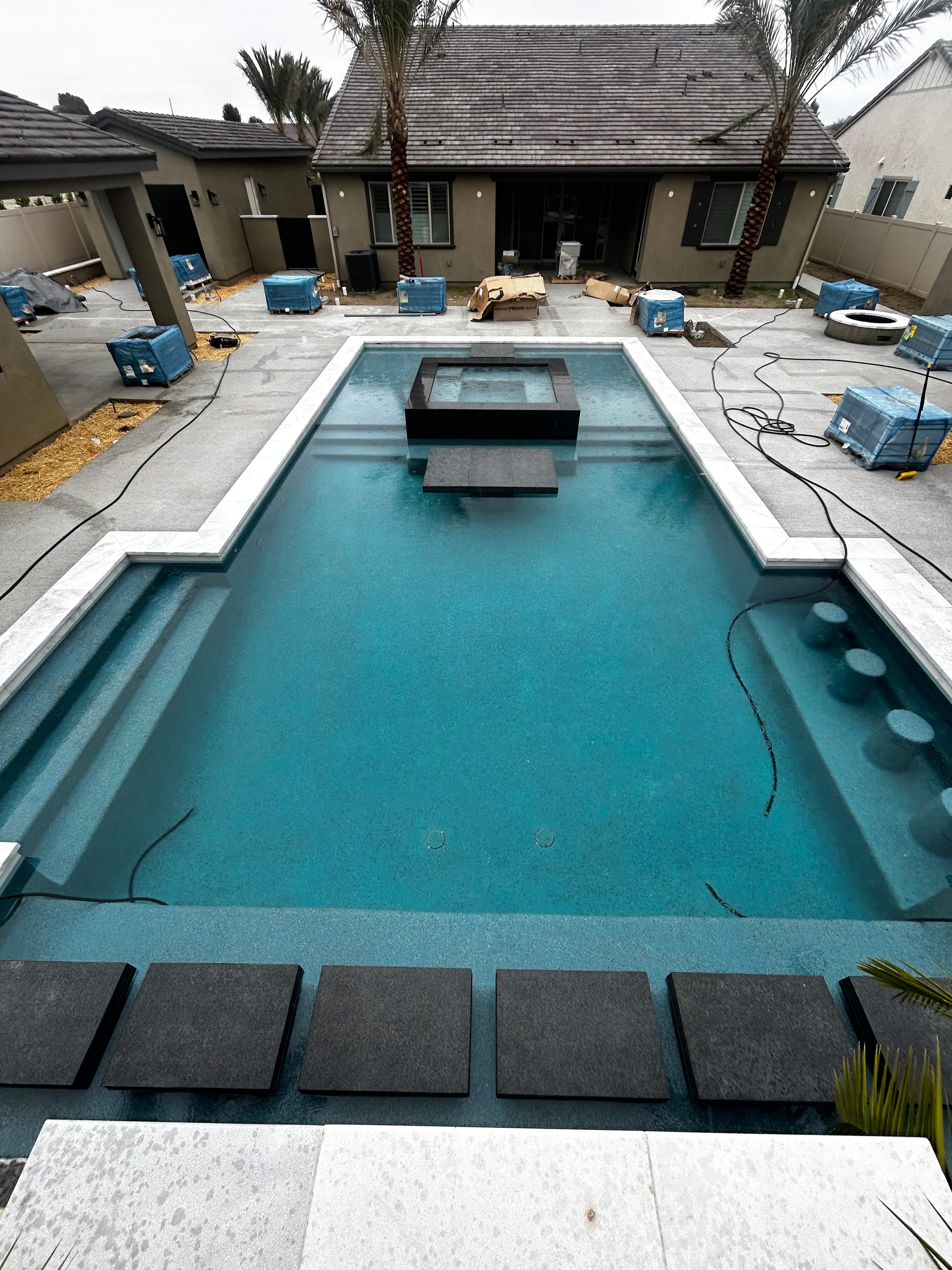 Pool spa zero edge spa, large water wall, floating steps, bar stools by Premier Pools and Spas Temecula