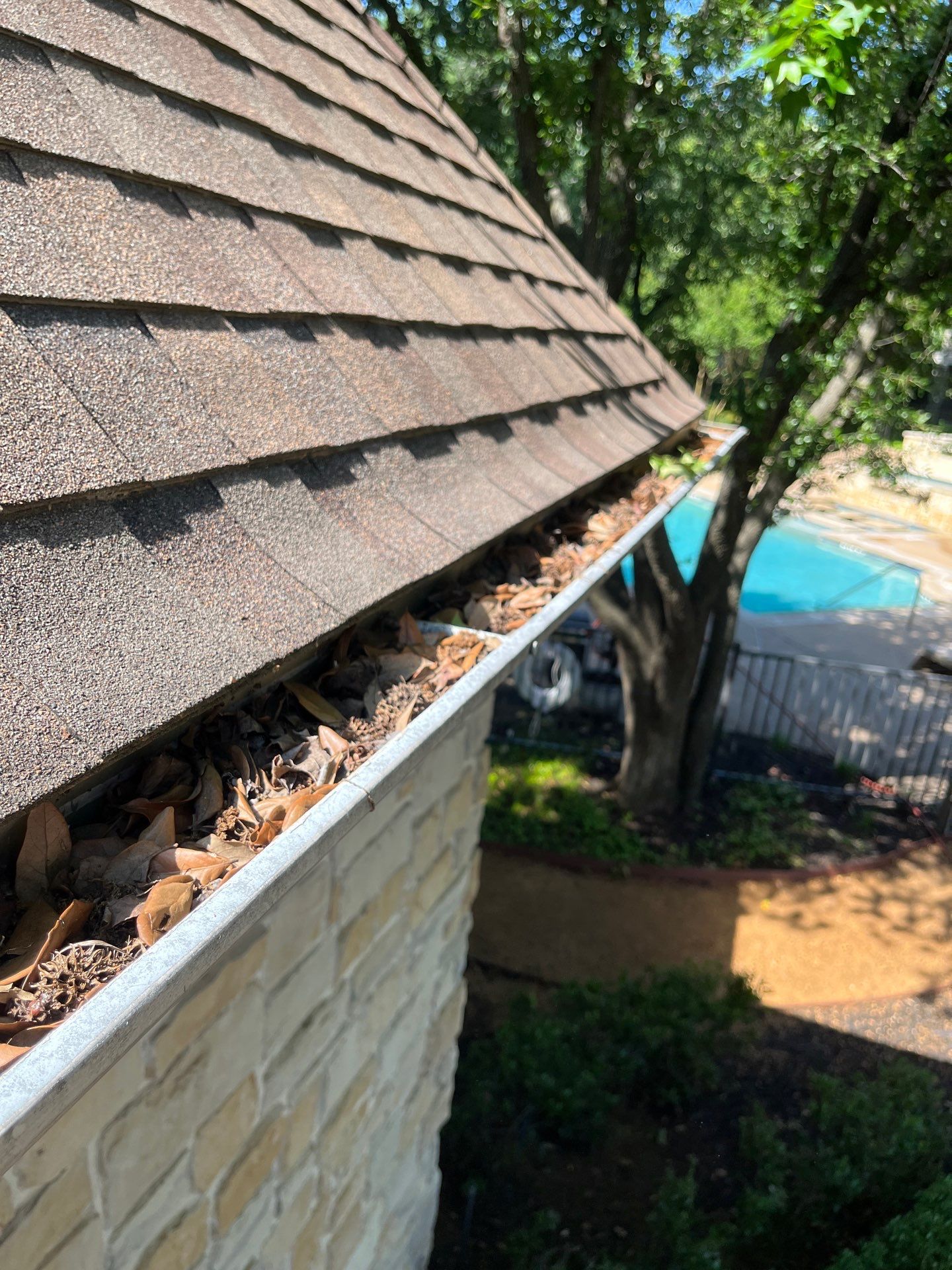 Commercial gutter cleaning Arlington & Grand Prairie, TX before photo with filled gutters
