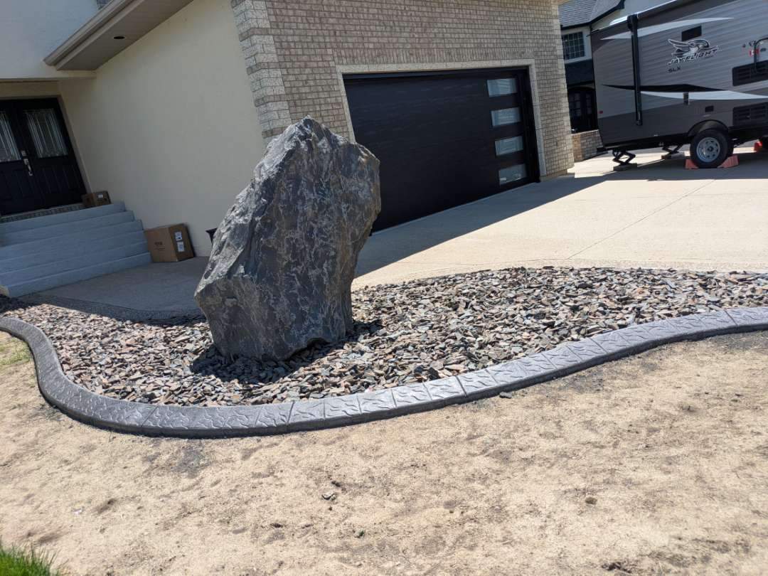 Custom Stamped Concrete Curbing and Decorative Rock Bed Installation by Pump it Up Concrete Jacking