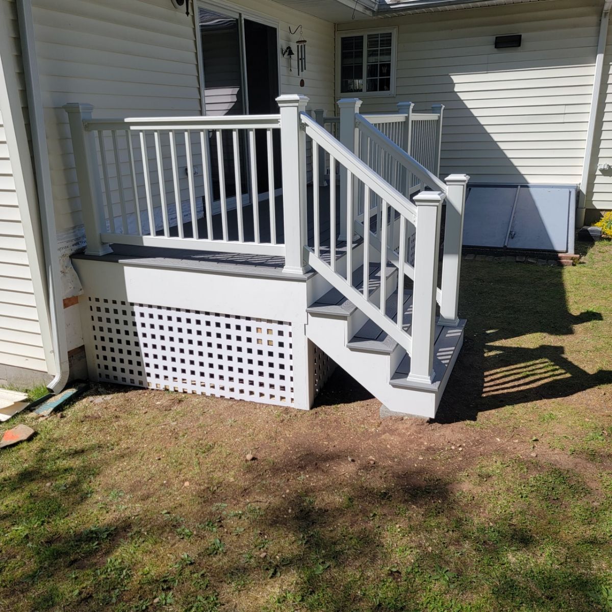 Replacement back deck using Trex Pebble Gray boards, White Composite railings and lattice. by DiGiorgi Roofing and Siding Inc