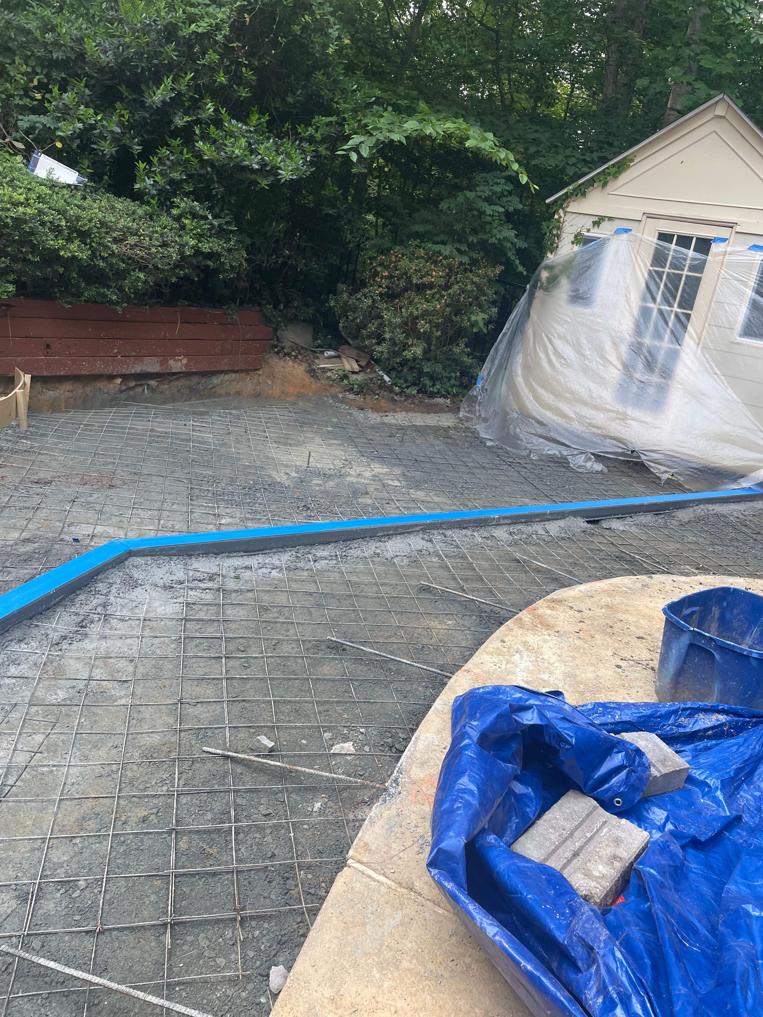 Pool Surround remodel with retaining walls, new waterfall and water slide by Fairfax Contractors, LLC