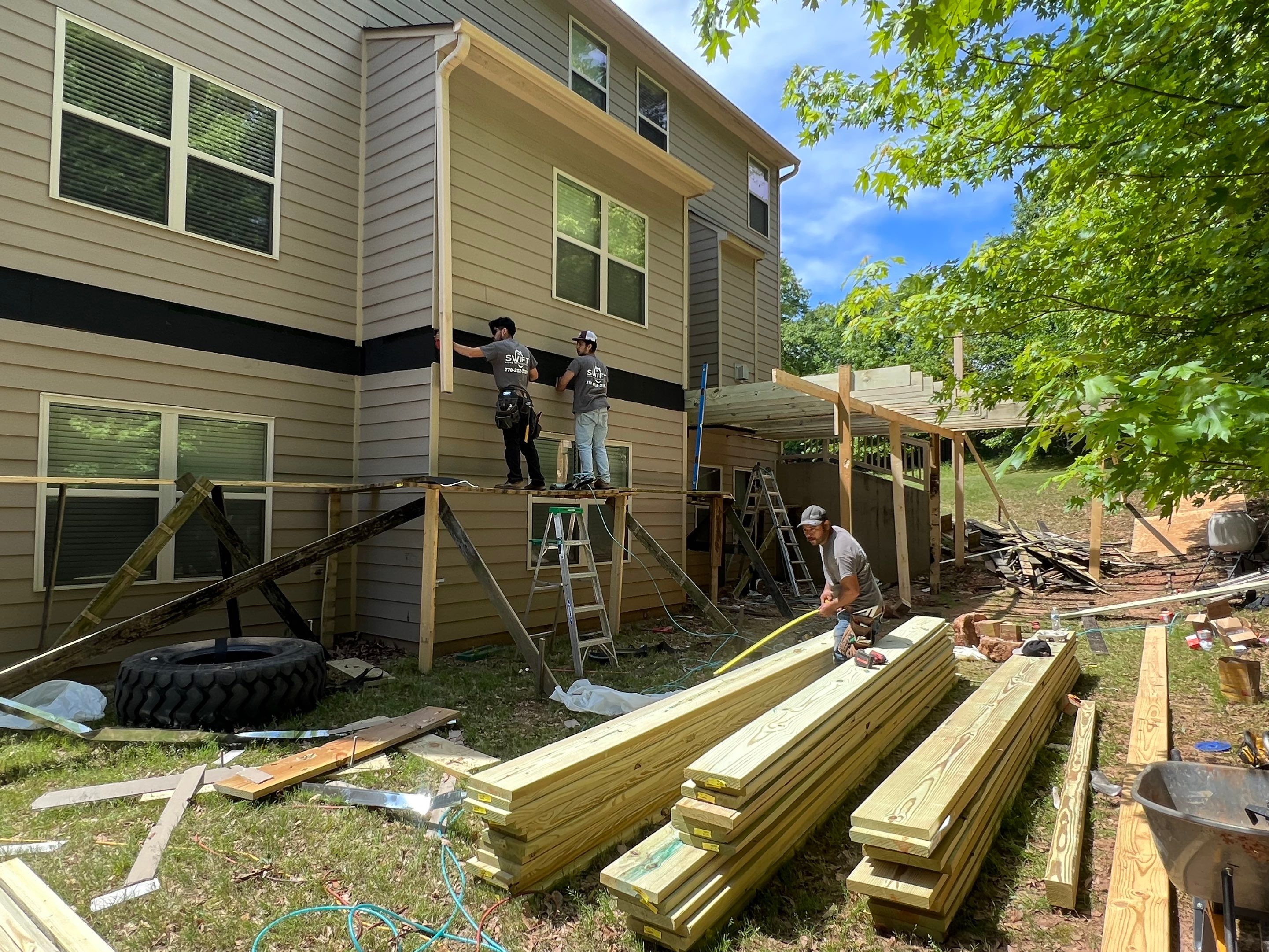 Custom Elevated Deck Replacement with White and Black Railings by Swift Home Renovations