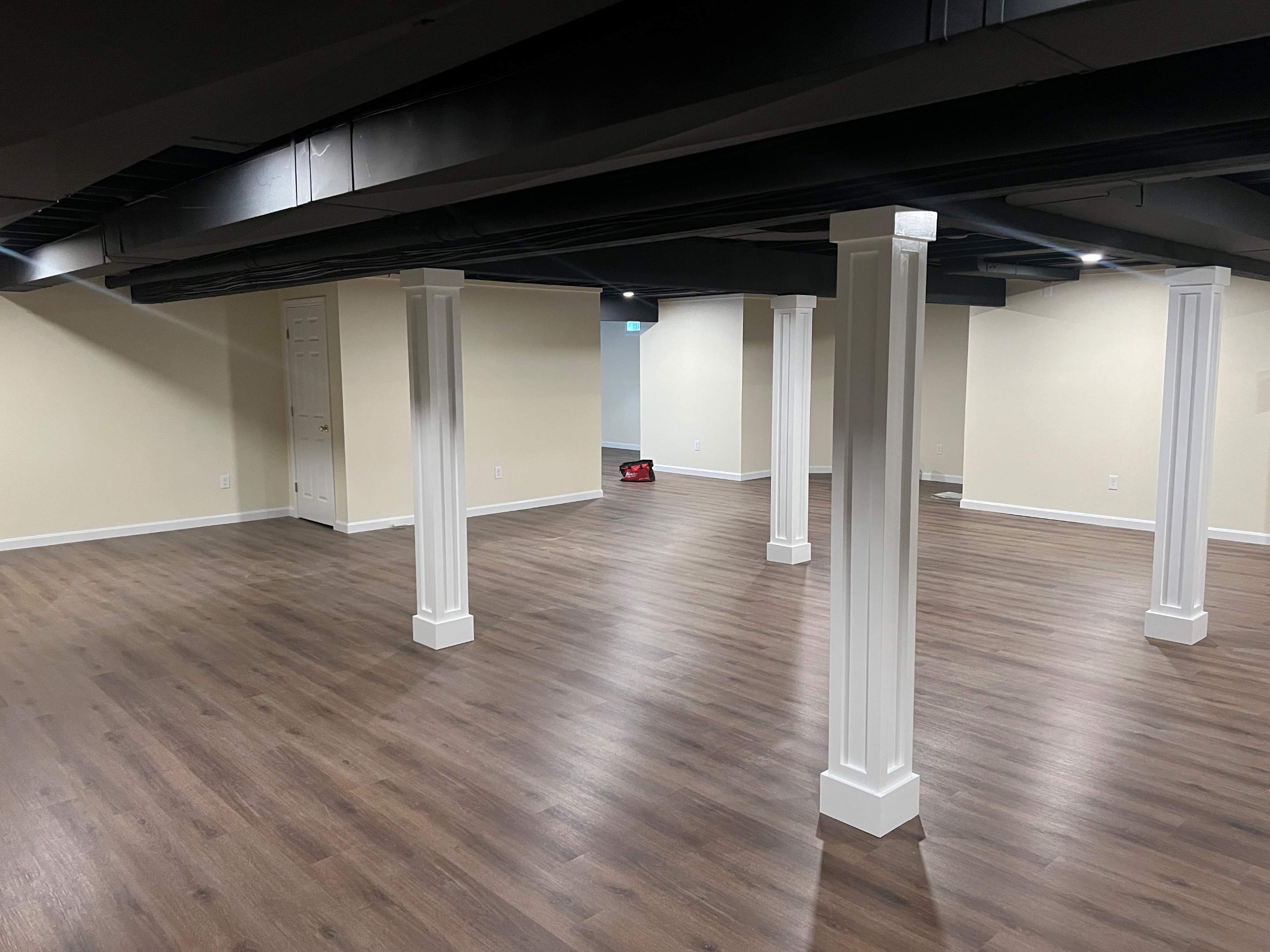 Basement Remodel w/ LVP Flooring & Exposed Ceiling by Chagnon Building & Remodeling LLC