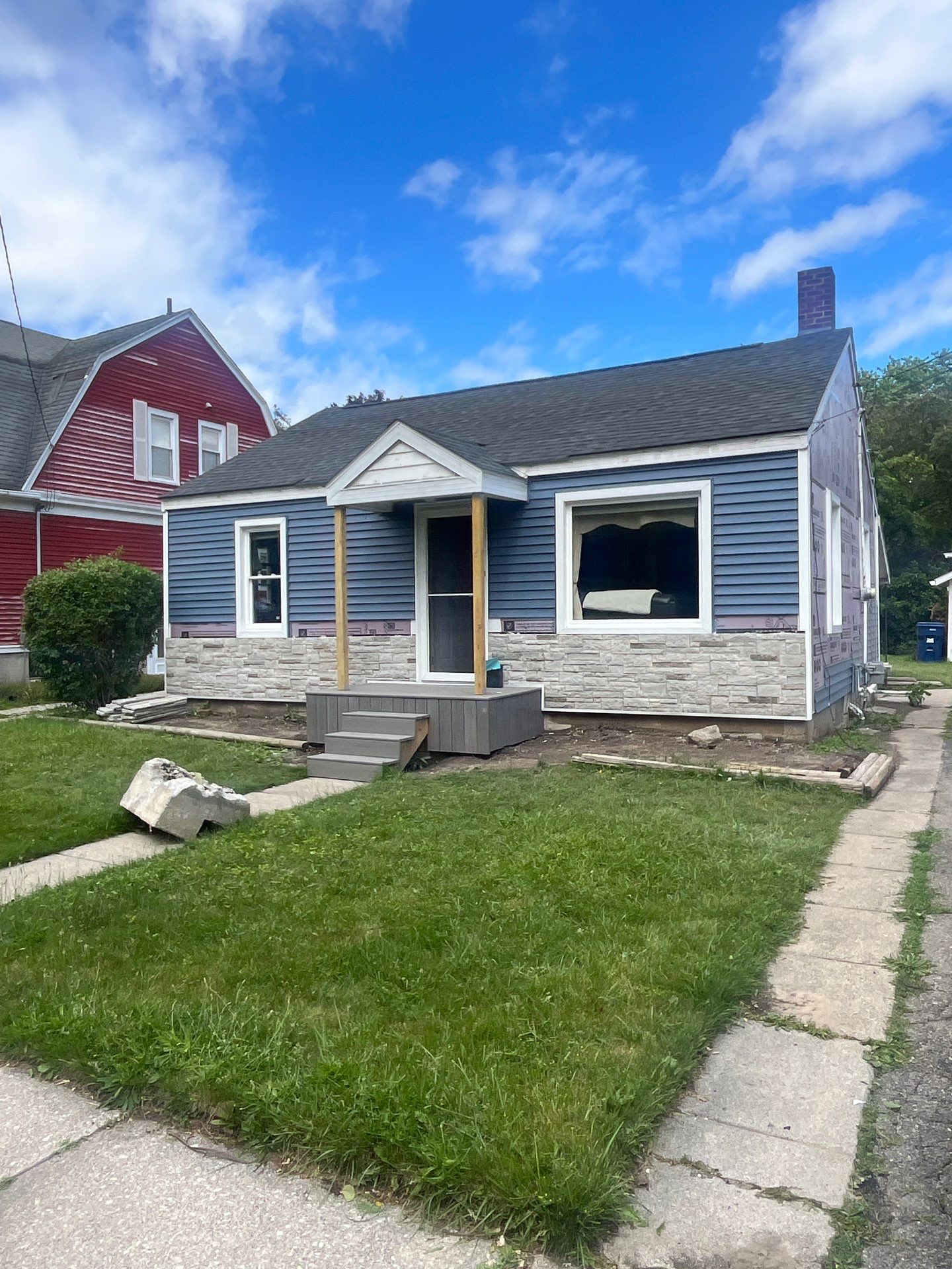 Blue Vinyl Siding and Versetta Stone Exterior Remodel in Bay City by Great Lakes Home Design LLC