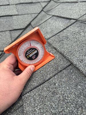 Angle gauge on an architectural asphalt shingle roof.