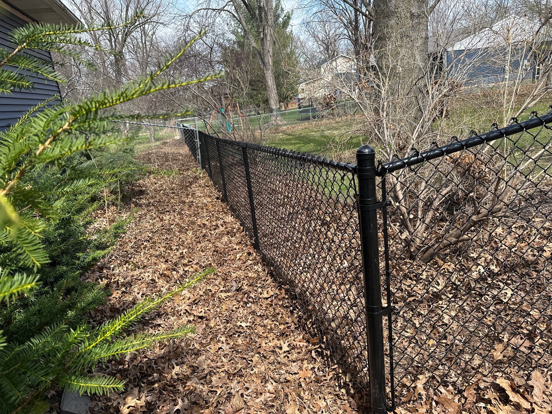 Black Vinyl-Coated Chain Link Fence Installation in Cedar Falls by Perfect Picket Fence and Stain
