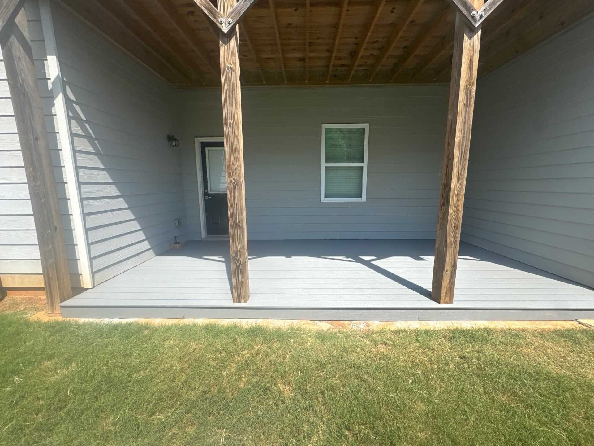 Ground-Level Gray Composite Deck and Privacy Fence Installation by Swift Home Renovations