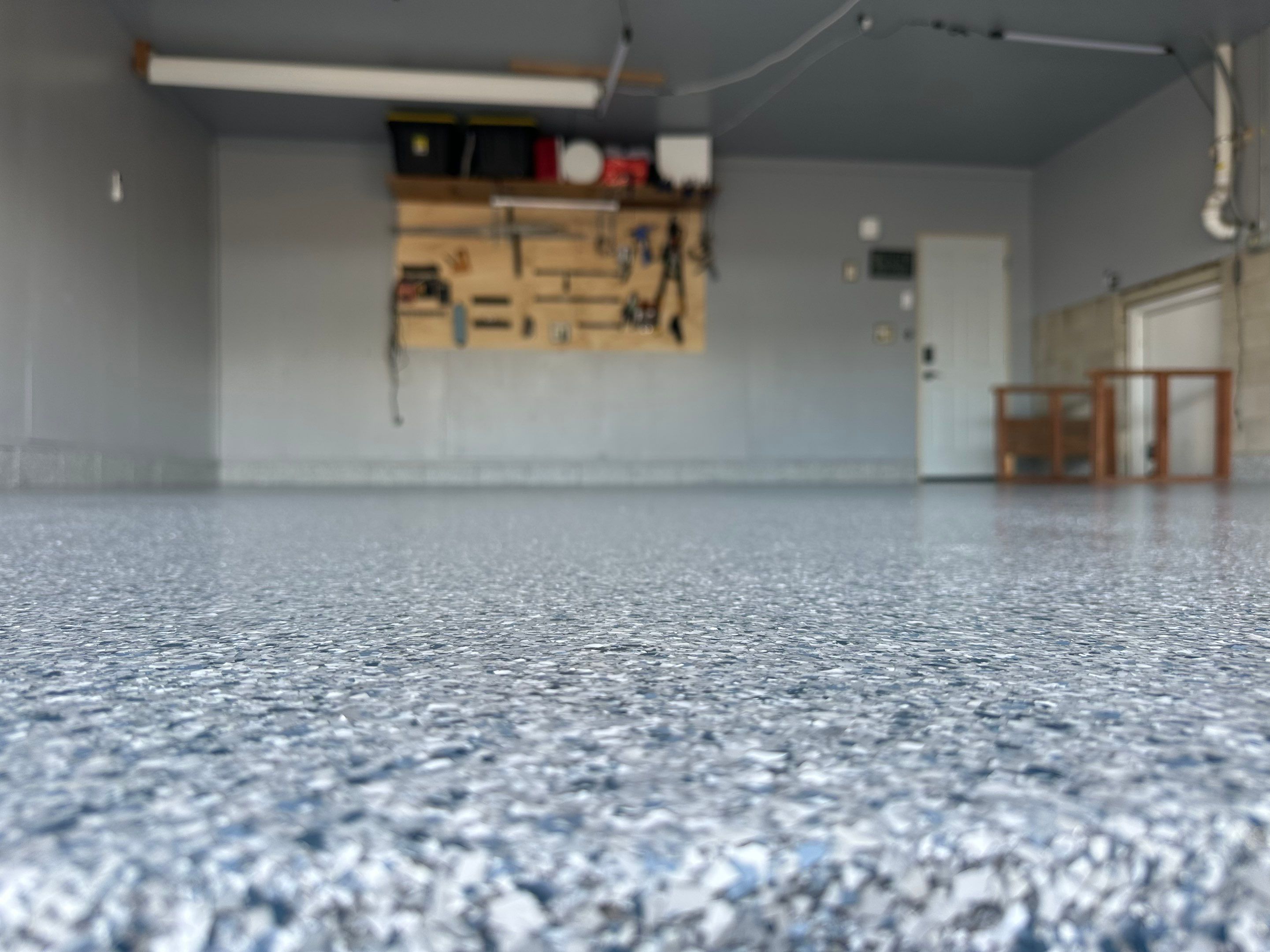 Multi-Colored Speckled Concrete Floor Coating Installation in Sioux Falls by Select Painting, Coatings & Garage Cabinets