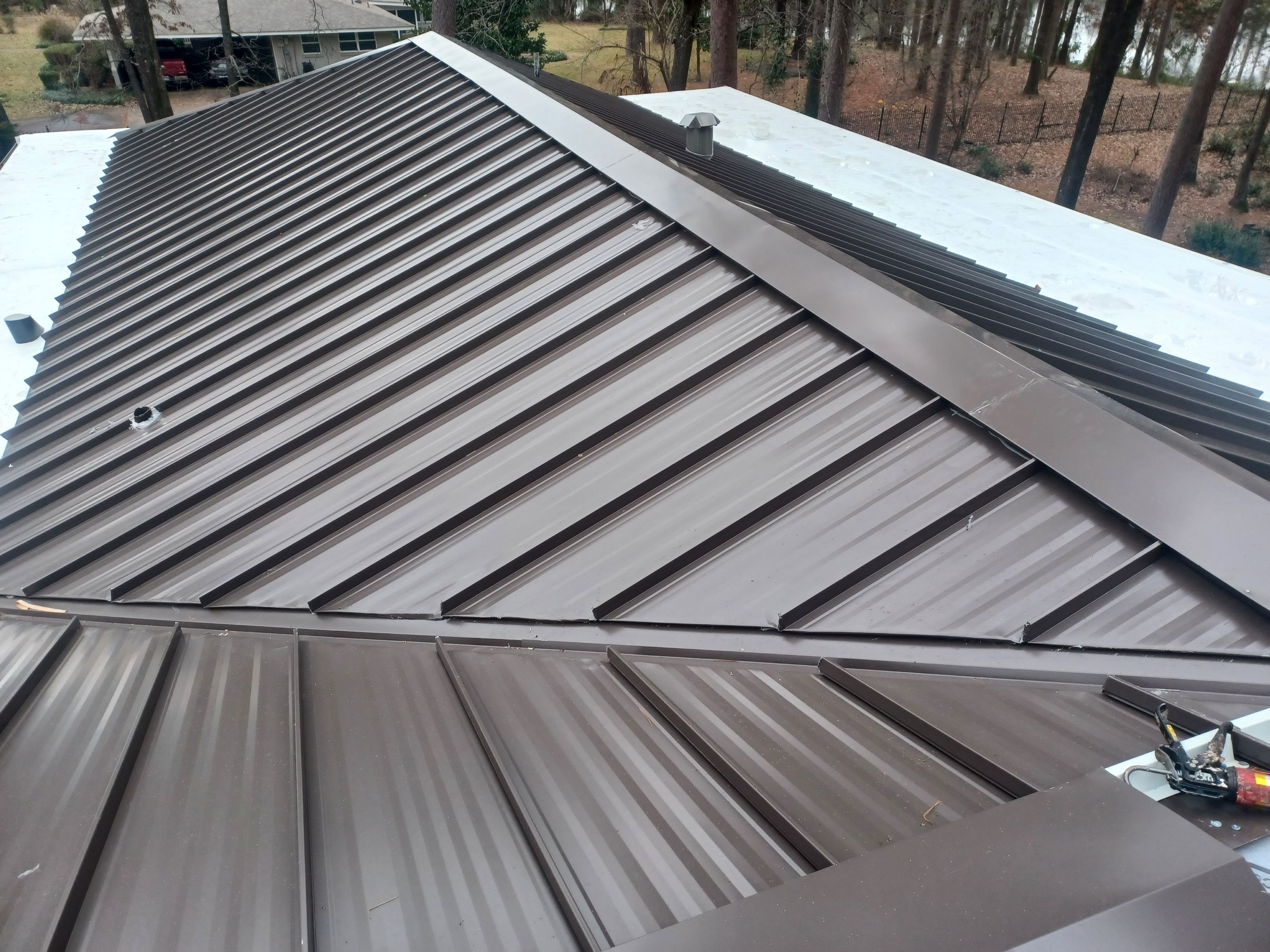 Residential Roofing Installation using PVC membrane and 24 gauge Standing Seam Metal by Hostetler Roofing