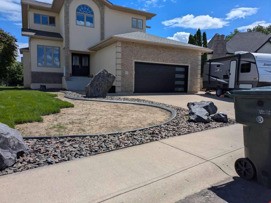Custom Stamped Concrete Curbing and Decorative Rock Bed Installation by Pump it Up Concrete Jacking