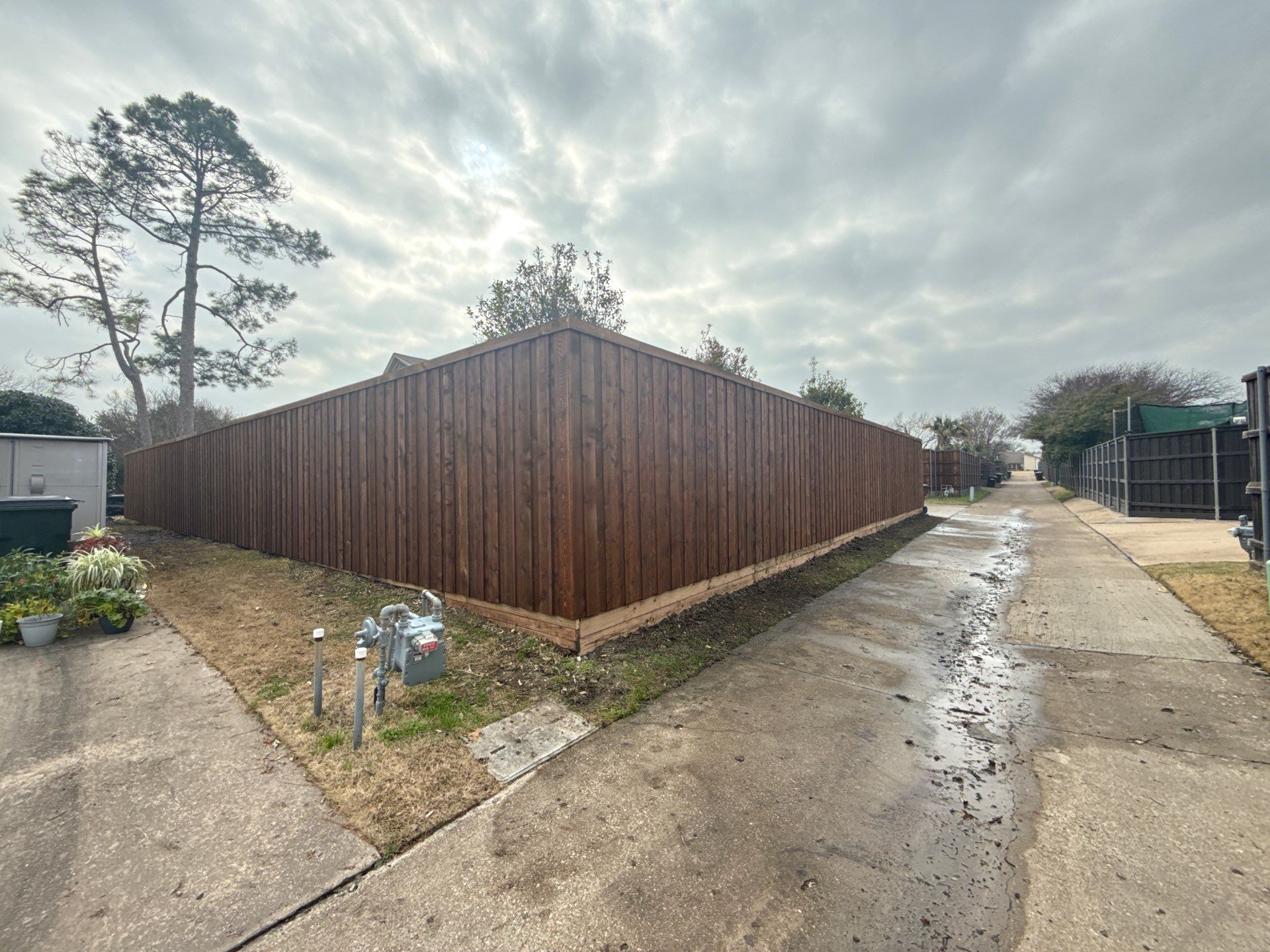 Pre-Stained board on board w/ trim and kickboard using 1x4 cedar trim by Grizzly Fence And Patio