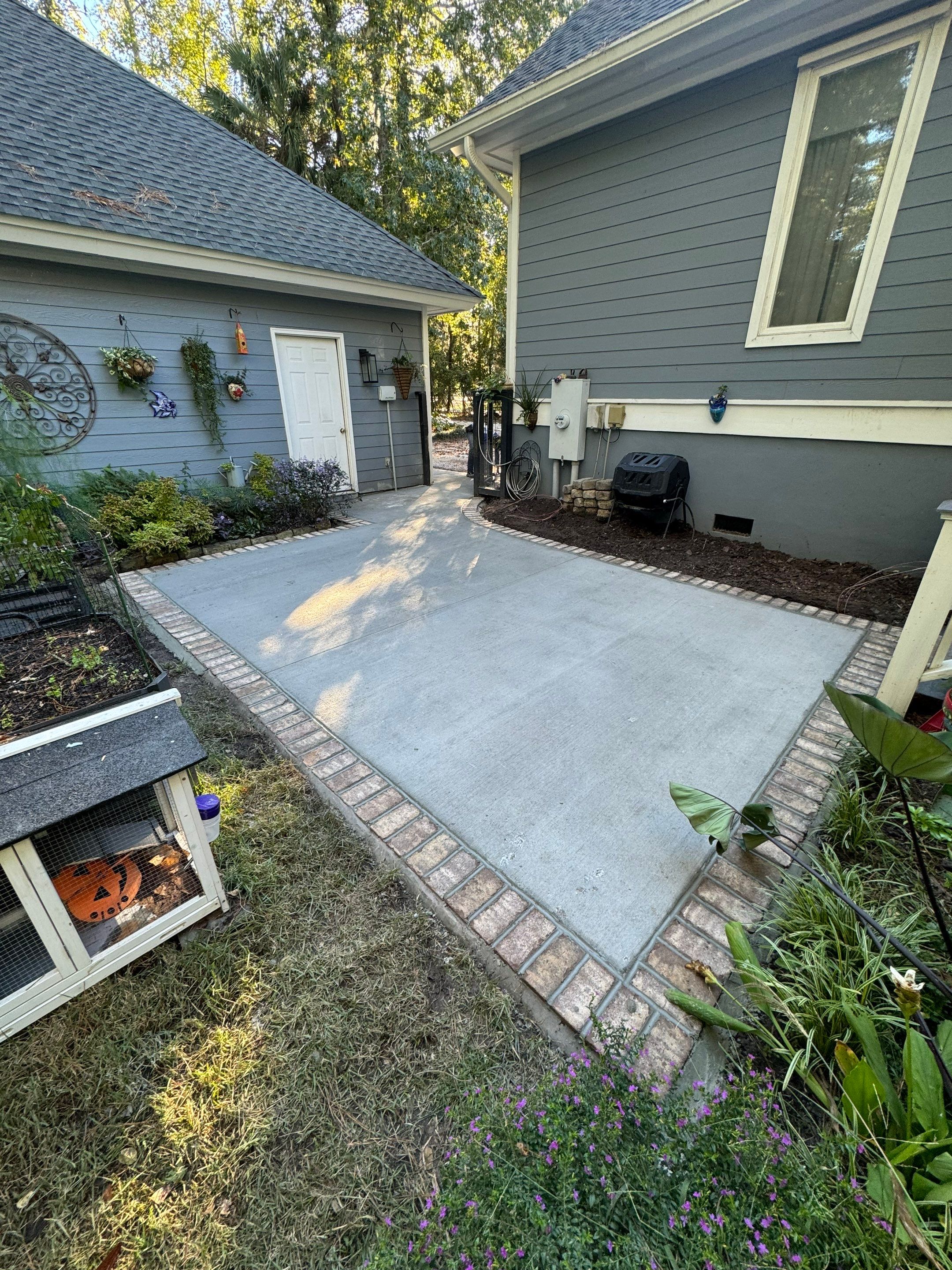 Concrete Driveway and Patio Installation With Decorative Brick Borders by Lowcountry Scapes, LLC