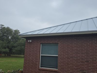 Side view of standing seam metal roof on brick.